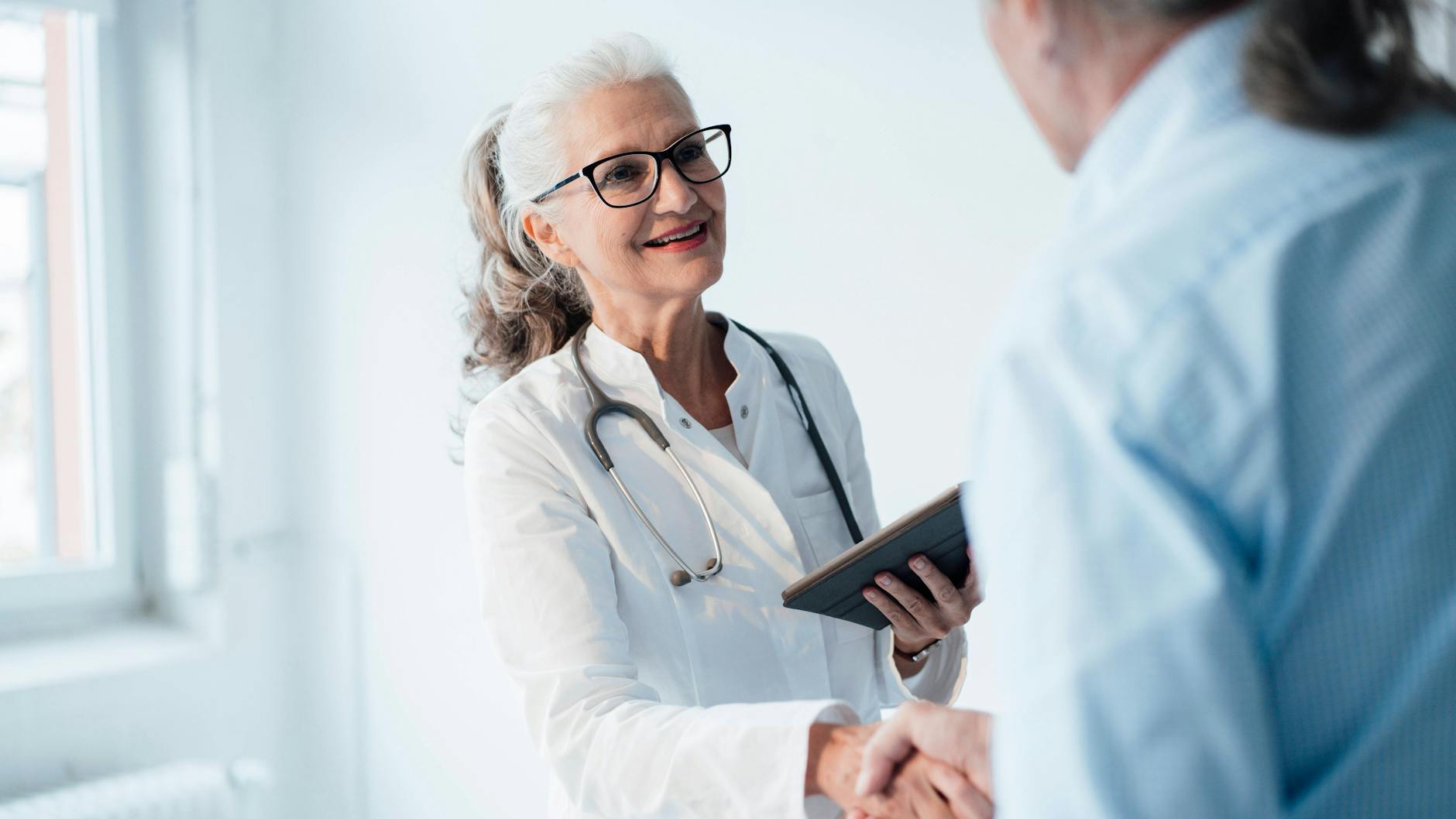 Eine Ärztin schüttelt die Hand eines Patienten. (Symbolbild)