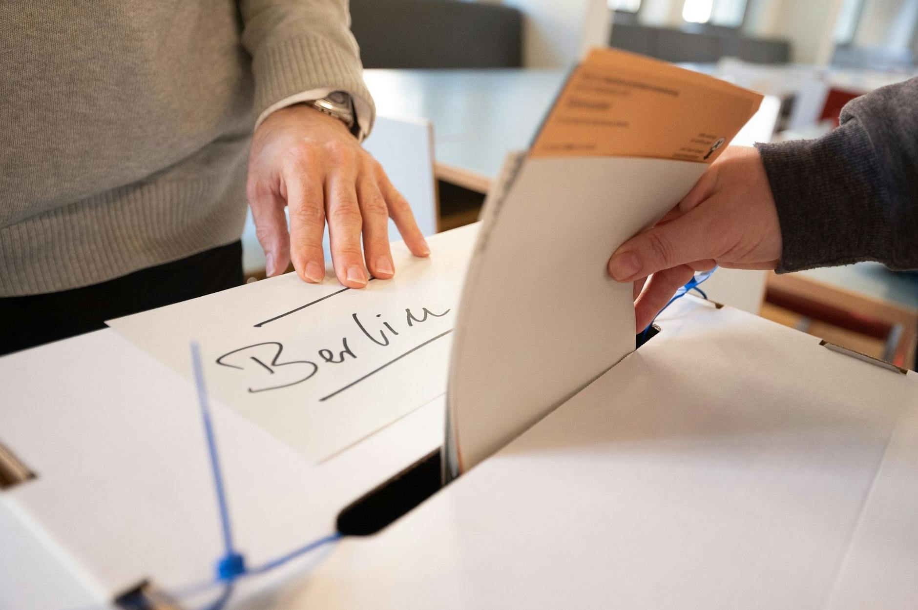 ARCHIV - Eine Frau gibt in einem Wahllokal Wahlzettel ab.