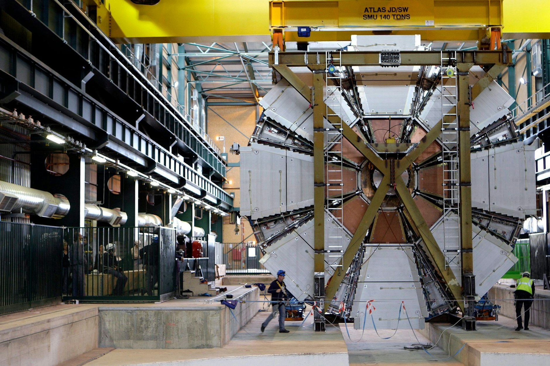 ARCHIV - Das letzte, 100 Tonnen schwere Element des Atlas-Experiments wird in die Höhle der Europäischen Organisation für Kernforschung CERN in Meyrin bei Genf hinabgelassen.  LE/dpa