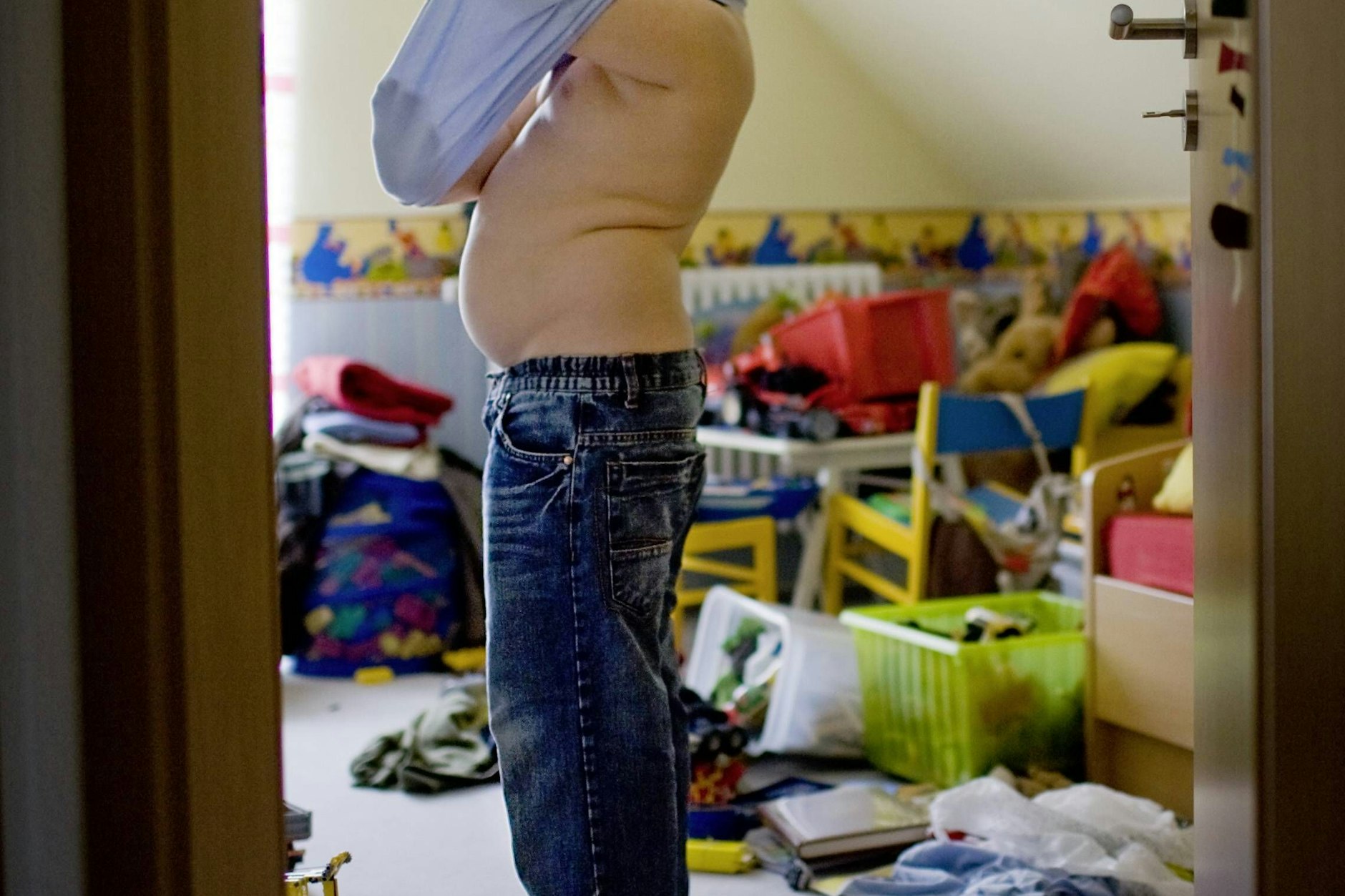 Übergewichtiger Junge beim Anziehen. In Brandenburg sind immer mehr Kinder zu dick.