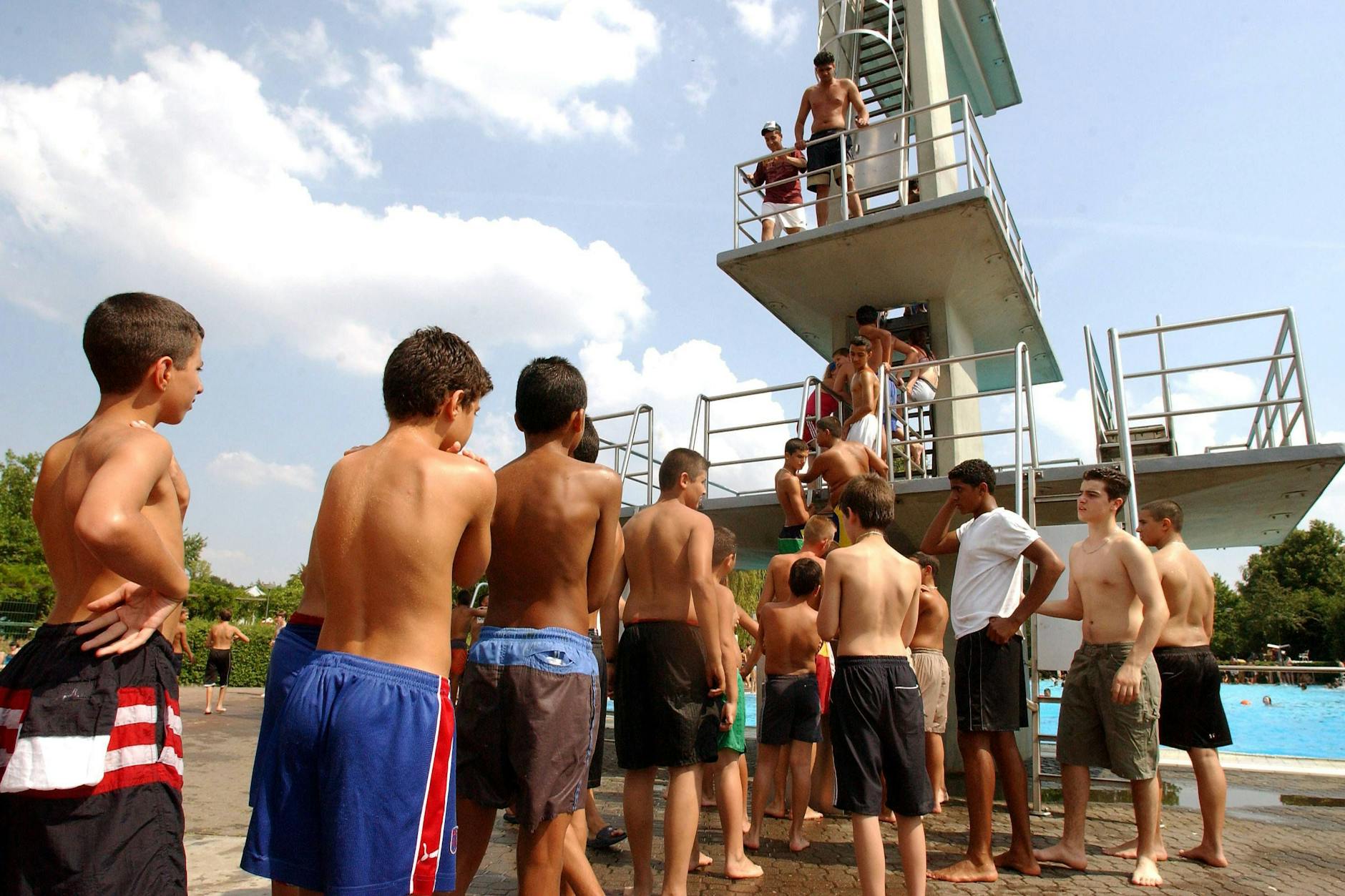 Erlebnishungrige Kinder und Jugendliche stehen Schlange vor dem Sprungturm des Columbiabads in Berlin-Neukölln.