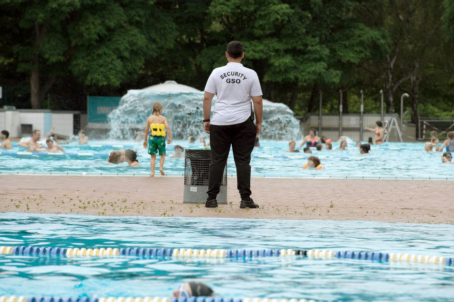 Ein Mitarbeiter des Sicherheitsdienstes Security GSO steht im Prinzenbad am Beckenrand.