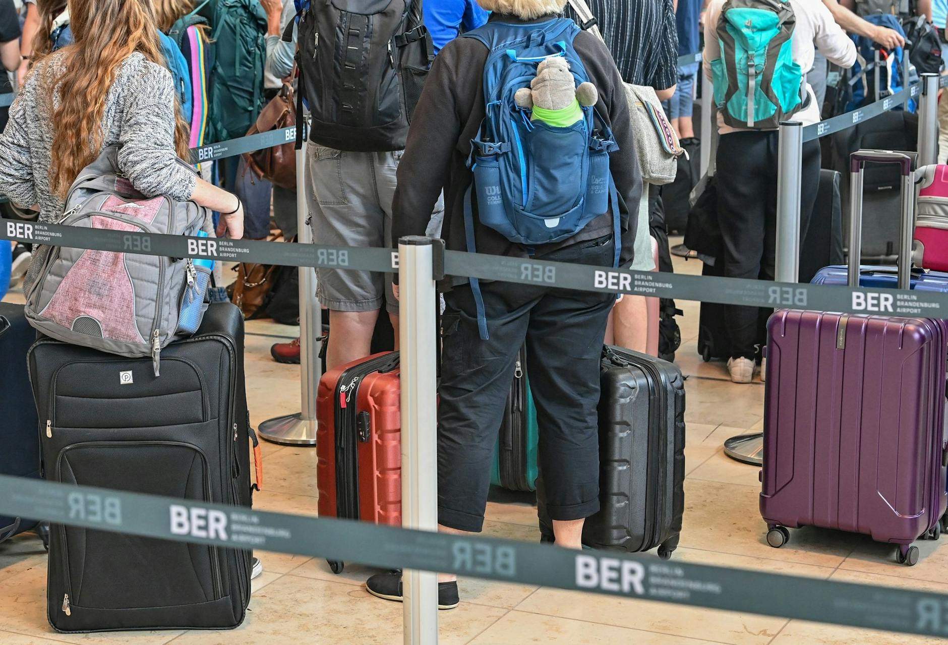 Reisende warten am Check-in für ihren Abflug vom Hauptstadtflughafen Berlin Brandenburg (BER).