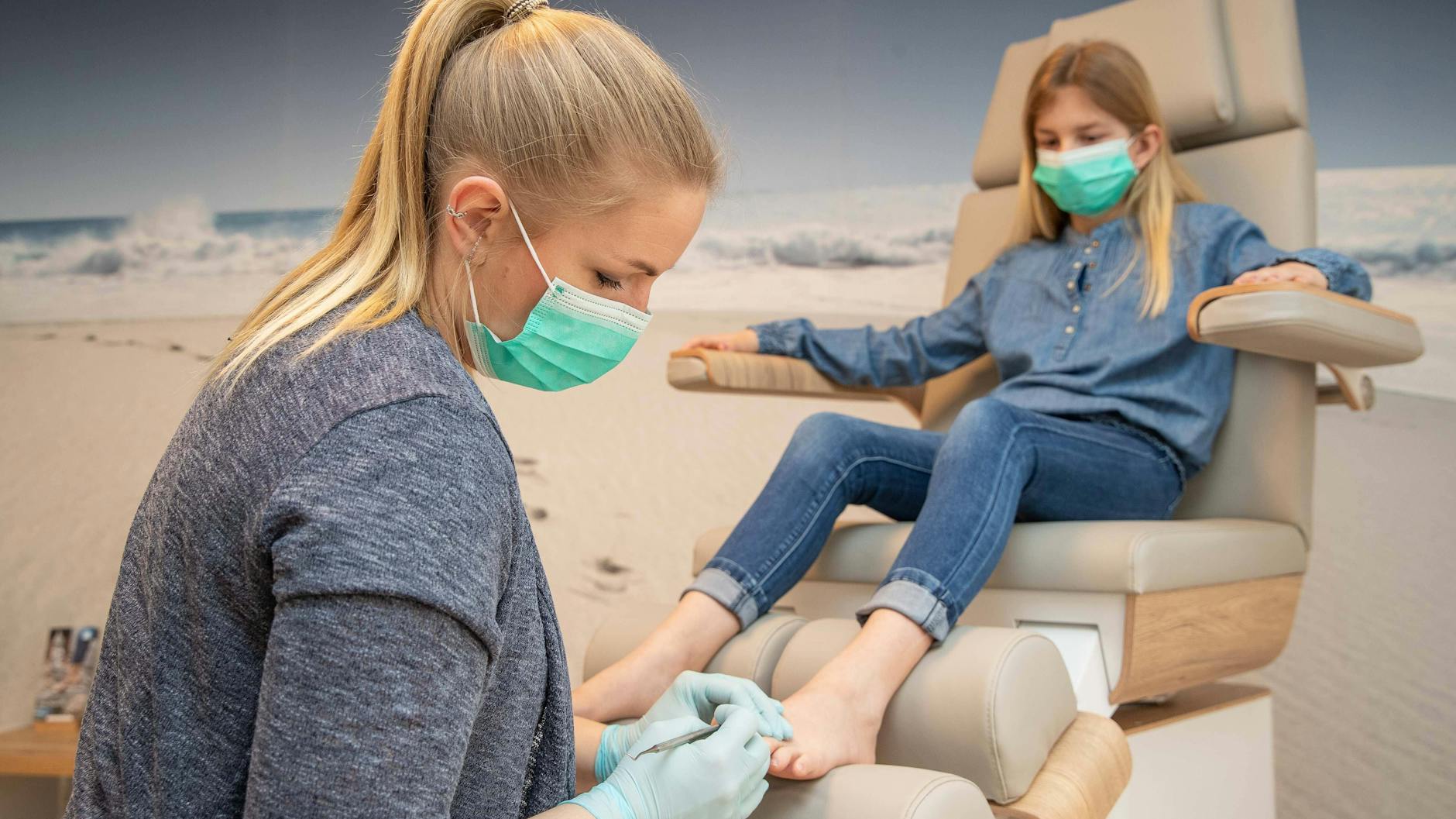 Eine Podologin behandelt die Füße eines Mädchens. Falsches Schuhwerk setzt Kinderfüßen zu.