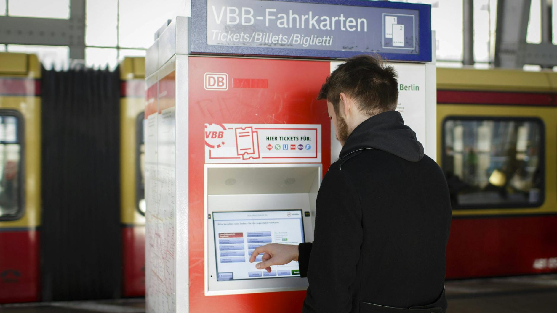 Ein Mann kauft sich einen Fahrschein an einem Automaten am Alexanderplatz.