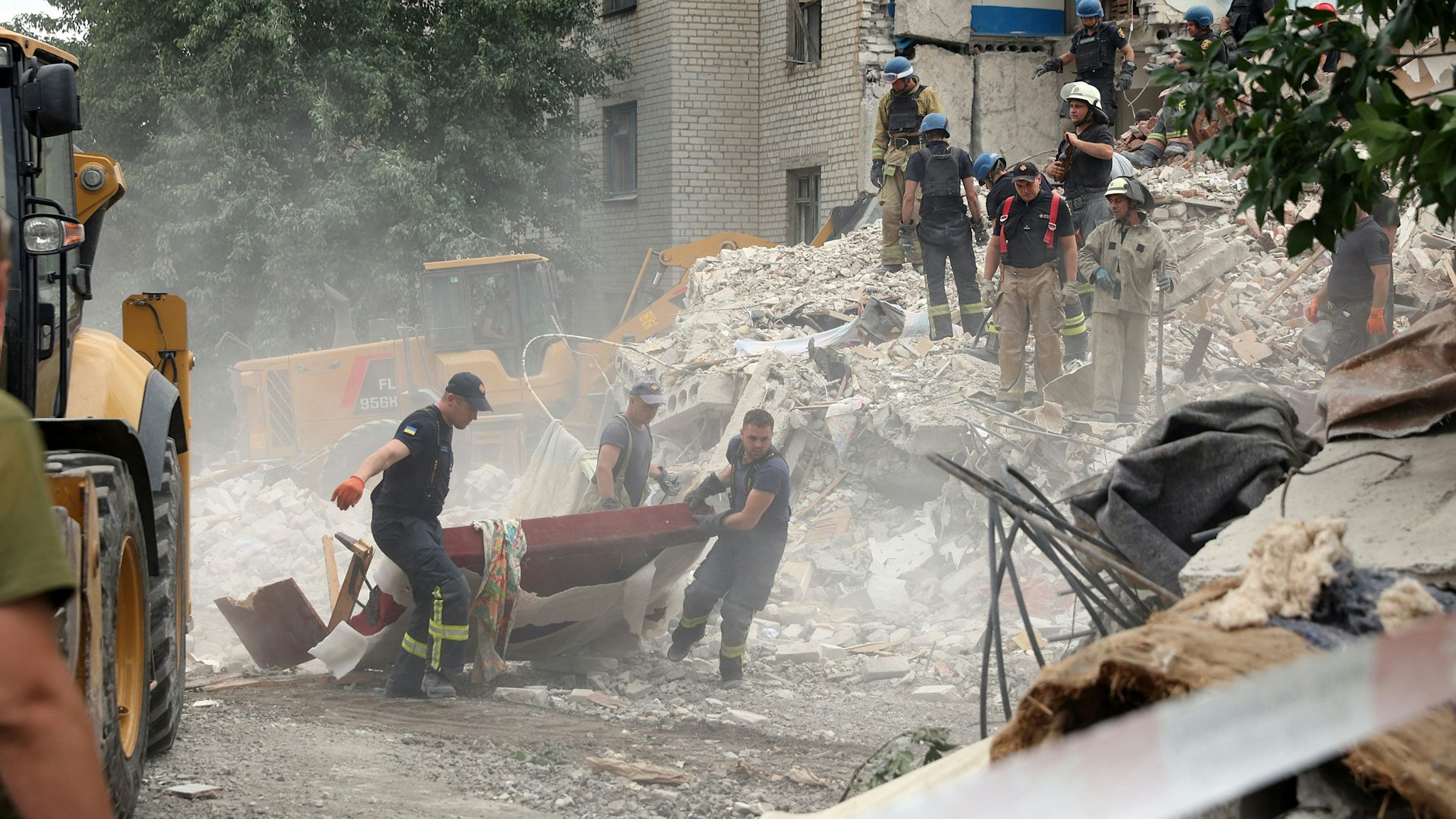 Retter räumen auf, nachdem ein Gebäude bei Beschuss in Chasiv Jar zerstört wurde.