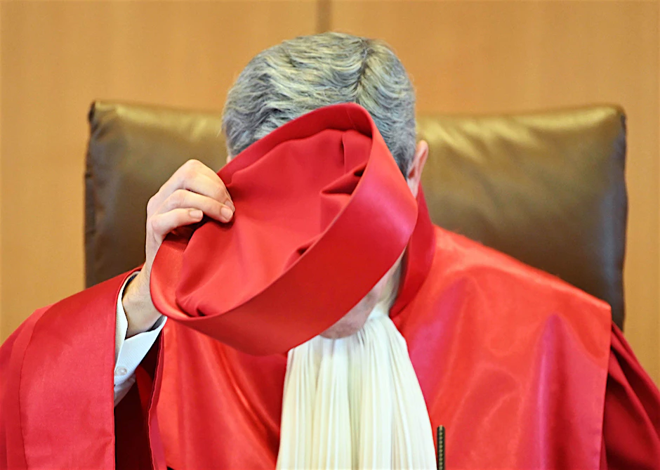 Stephan Harbarth, Vorsitzender des Ersten Senats beim Bundesverfassungsgericht, setzt zur Urteilsverkündung sein Richterbarett auf.