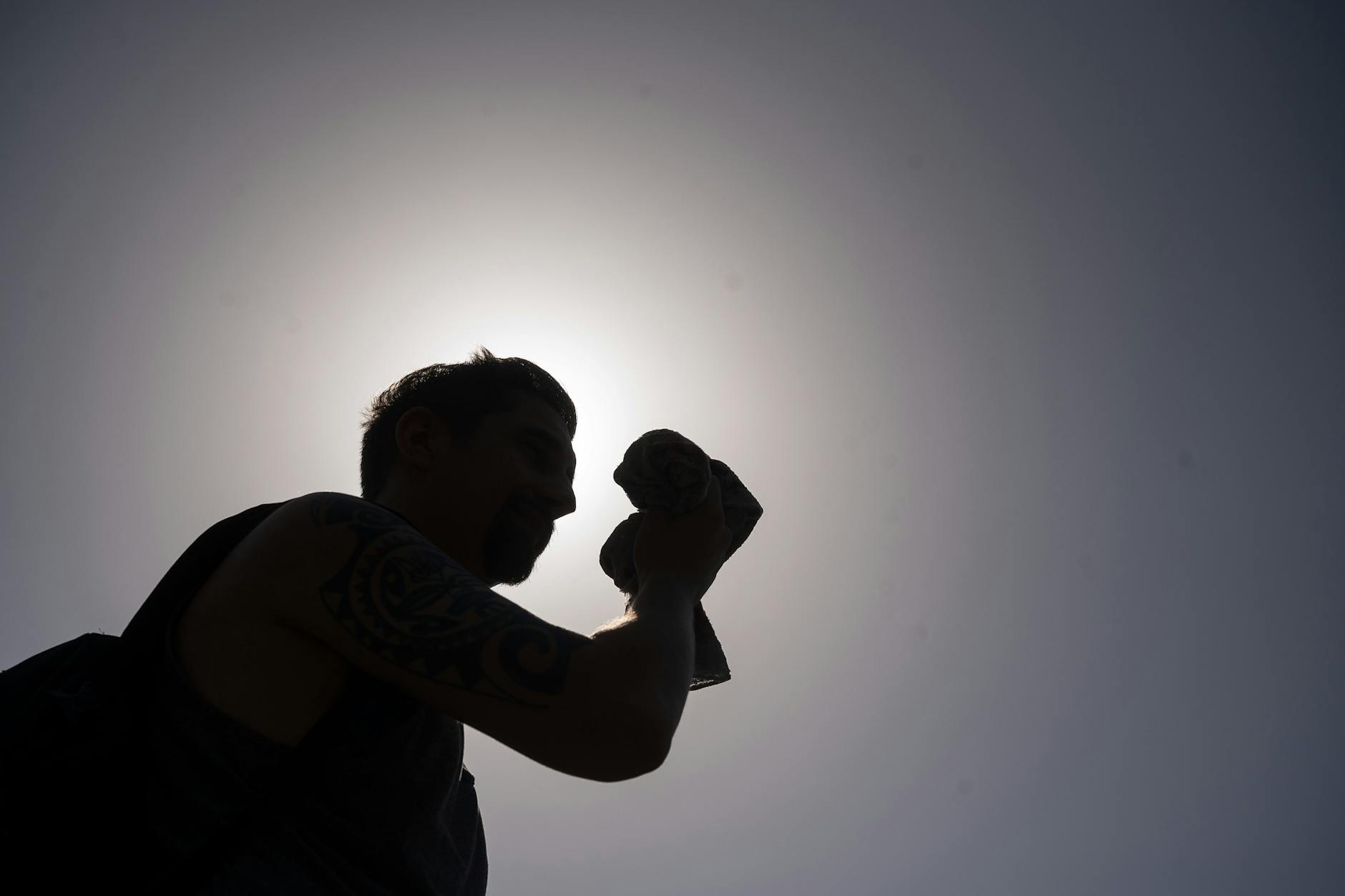 Ein Mann trocknet sich den Schweiß von der Stirn. (Symbolbild)