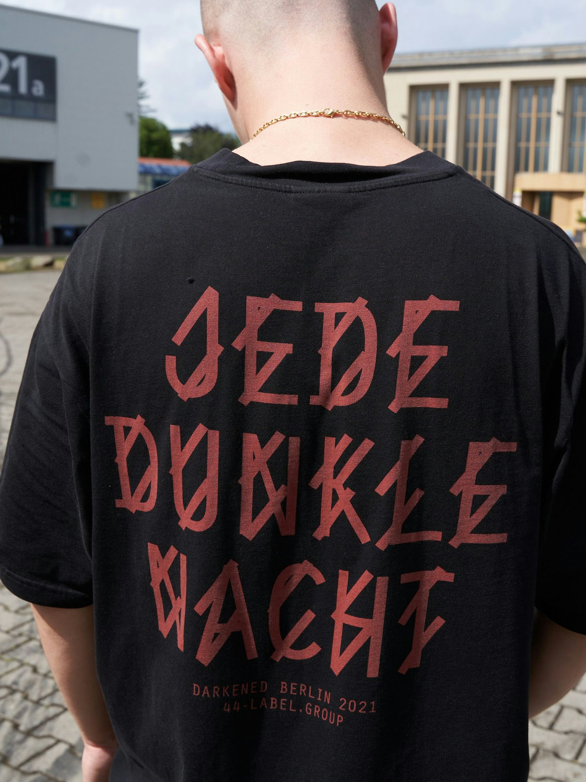 Die Slogans der 44 Label Group drehen sich um den Club. Zu Simon, der unter seinem bürgerlichen Namen Simon Kaiser auflegt, passen sie perfekt. Die Halskette hat er von seiner Ex-Freundin, erzählt Simon. Die Turnschuhe sind Nike Tn's.