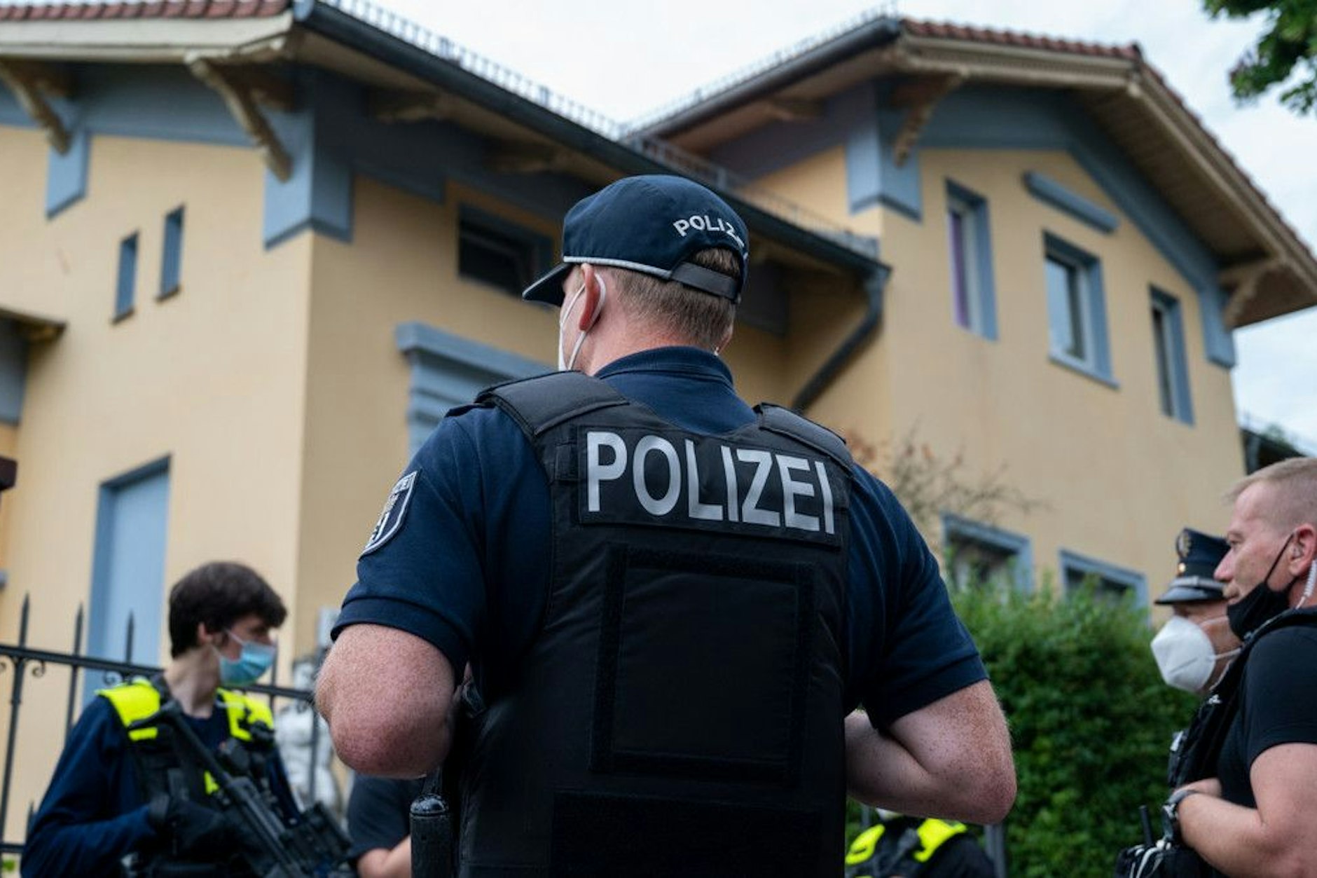 Polizisten stehen vor einem Berliner Wohnhaus von Mitgliedern eines bekannten arabischstämmigen Clans. Das Haus ist beschlagnahmt, trotzdem wohnt die Familie weiter dort.