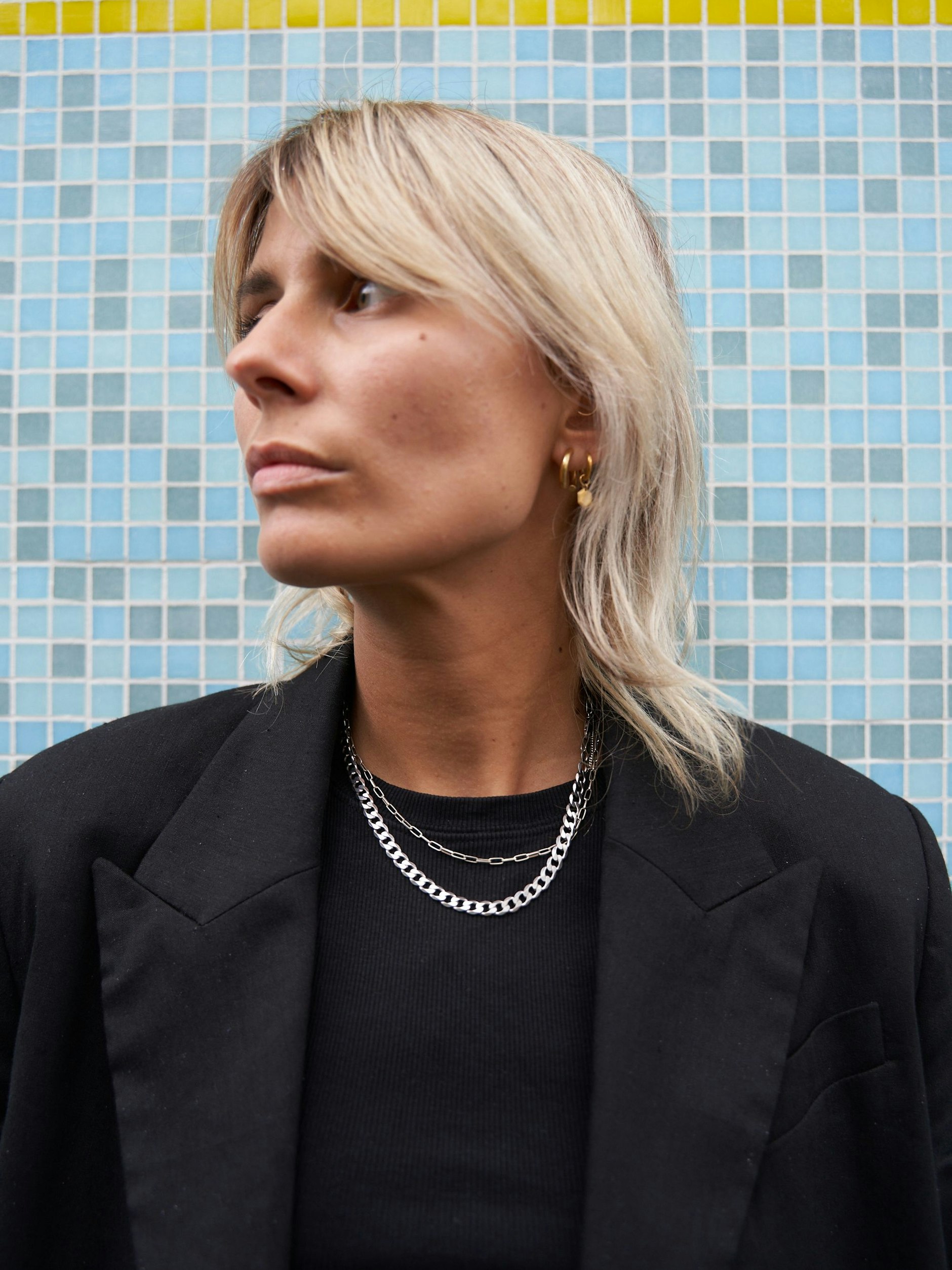 Zum rausgewachsenen Wolf Cut kombiniert Alex Schmuck von Maria Black.