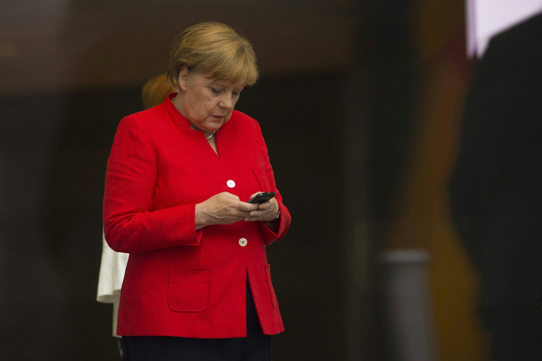 Die damalige Bundeskanzlerin Angela Merkel schreibt eine Nachricht auf ihrem Handy.