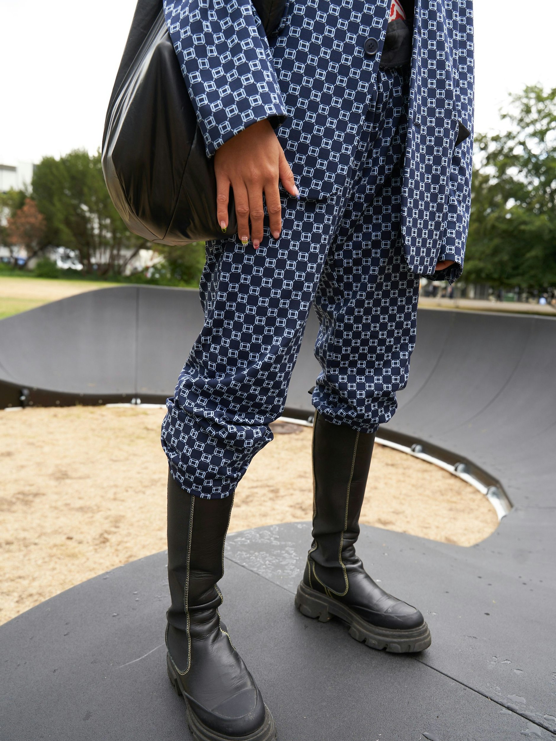 Sie trägt einen Männeranzug von Drykorn. Die deutsche Marke hatten wir ja eigentlich schon fast vergessen. Zu Unrecht, wie wir auf dem Festival immer wieder feststellen konnten. Die Stiefel sind von Ganni, von P.A.R.O.S.H. die Tasche.