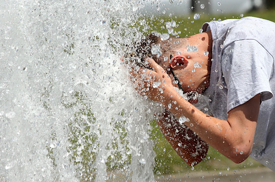 Bei Temperaturen um 29 Grad Celsius erfrischt sich ein junger Mann im Berliner Lustgarten.