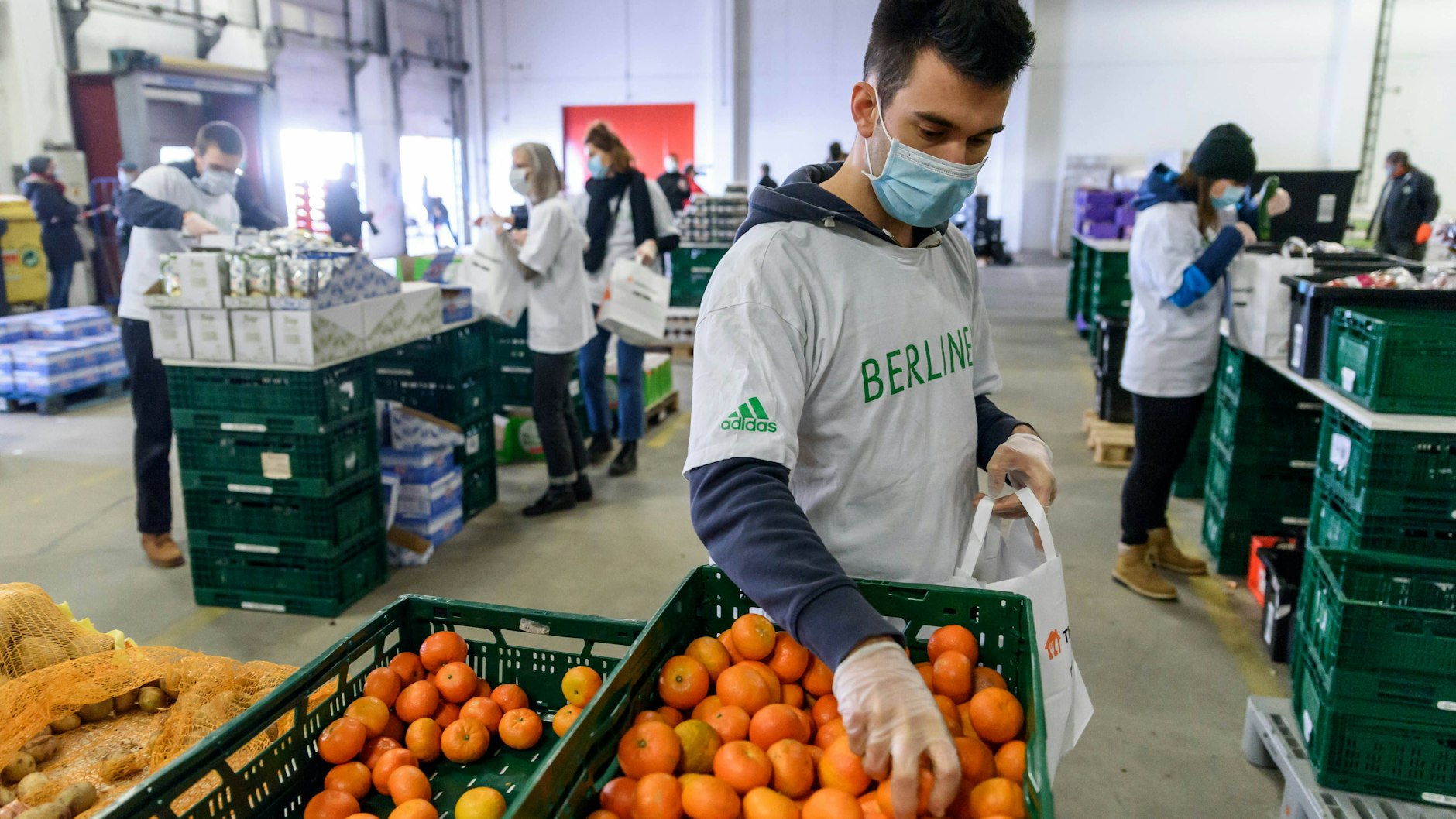Viele Berliner kommen nur noch über die Runden, weil sie von der Berliner Tafel versorgt werden. Hier packen in einer Halle des Berliner Großmarkts ehrenamtliche Helfer der Berliner Tafel Lebensmittel in Tüten.