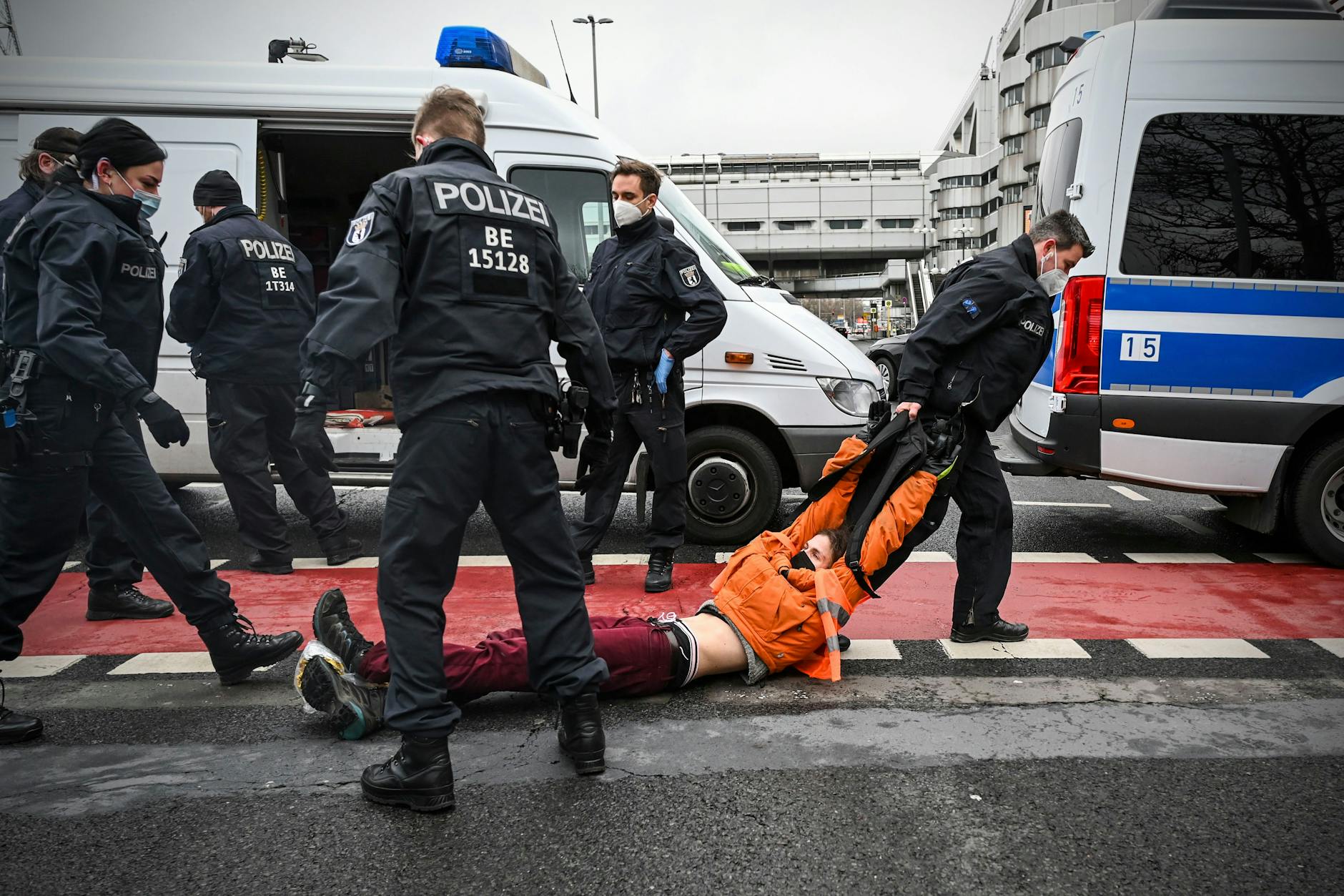 Polizisten entfernen am Messedamm Aktivisten, die die Straße blockieren.