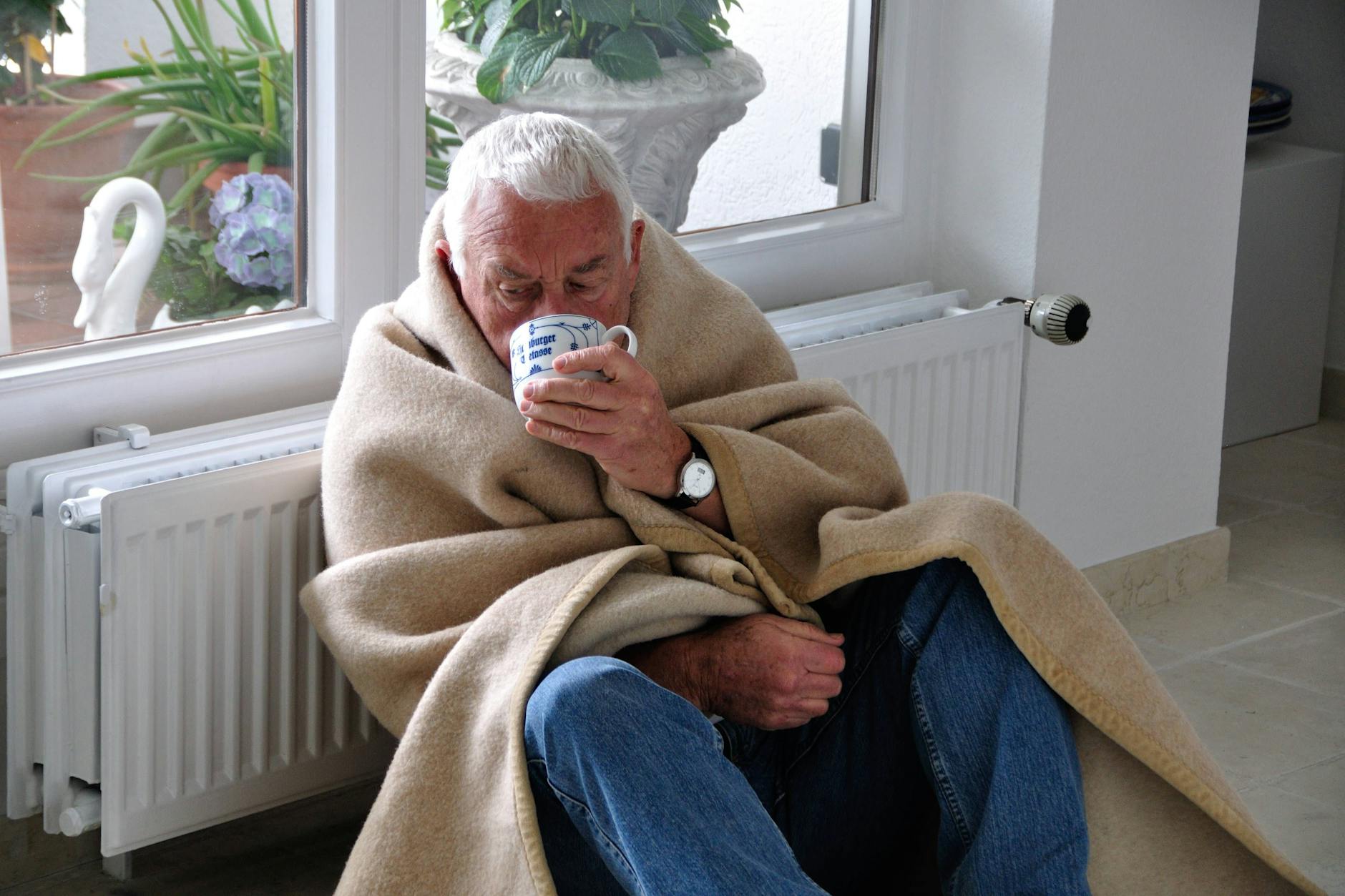 Mit Decke und Tee lässt sich eine geringere Raumtemperatur ertragen.