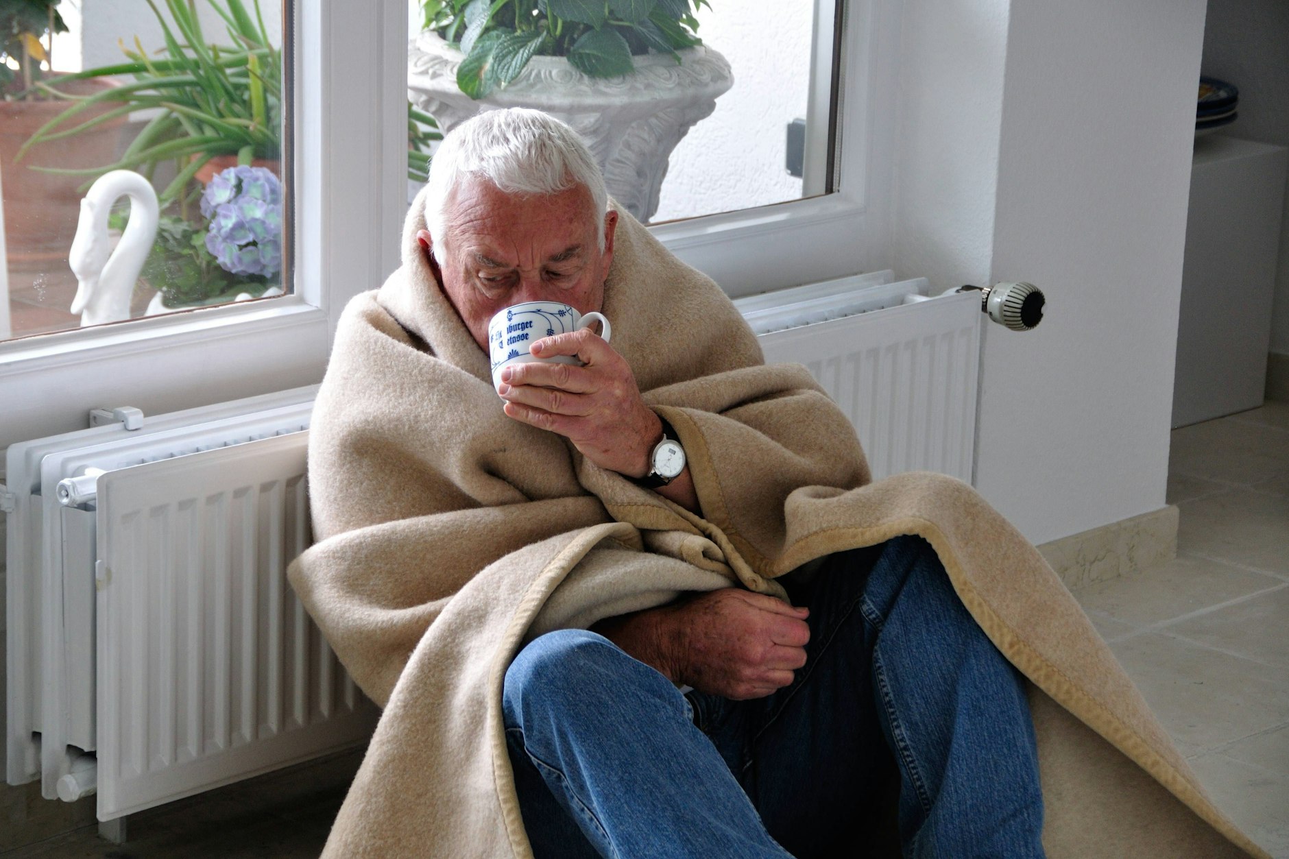 Mit Decke und Tee lässt sich eine geringere Raumtemperatur ertragen.