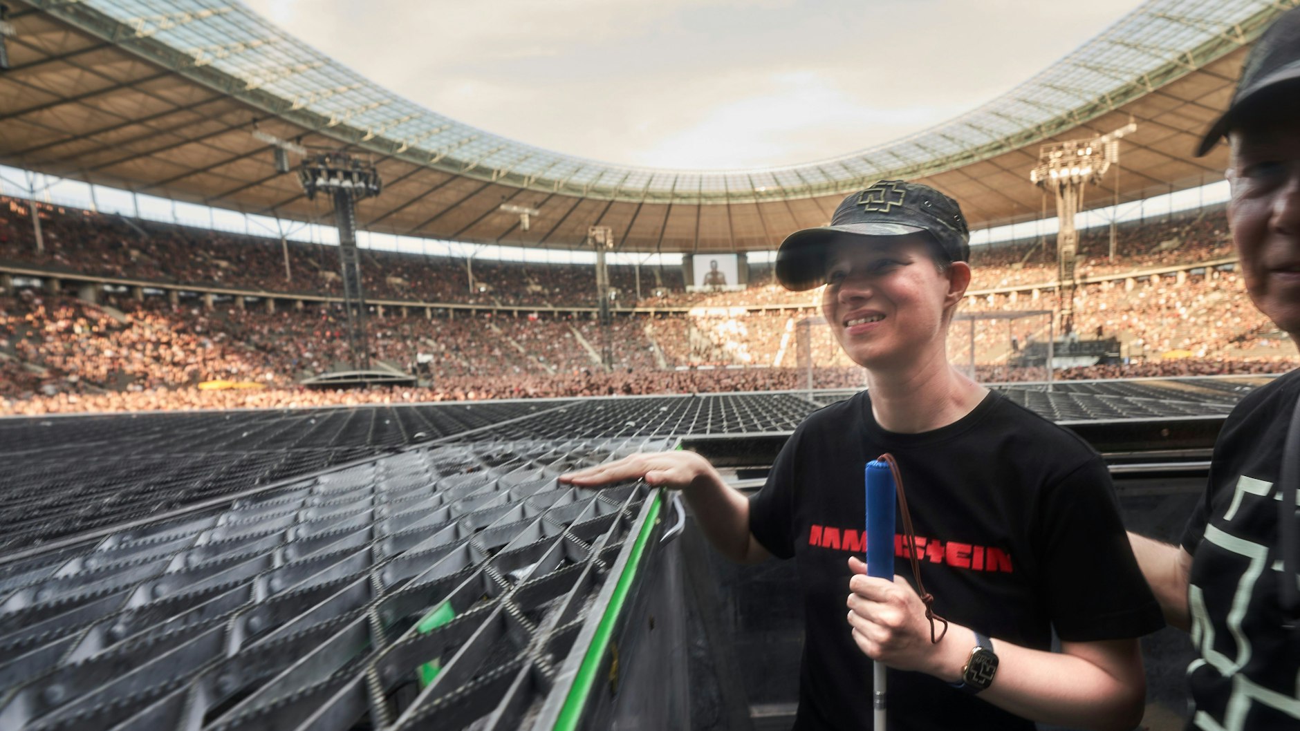 Harte Rocker, weiches Herz: Vor den Konzerten dürfen Menschen mit Sehbehinderung die Bühne erkunden. Hier: Die blinde Jasmin Wenz betastet das Gitter des Bühnenbodens im Olympiastadion