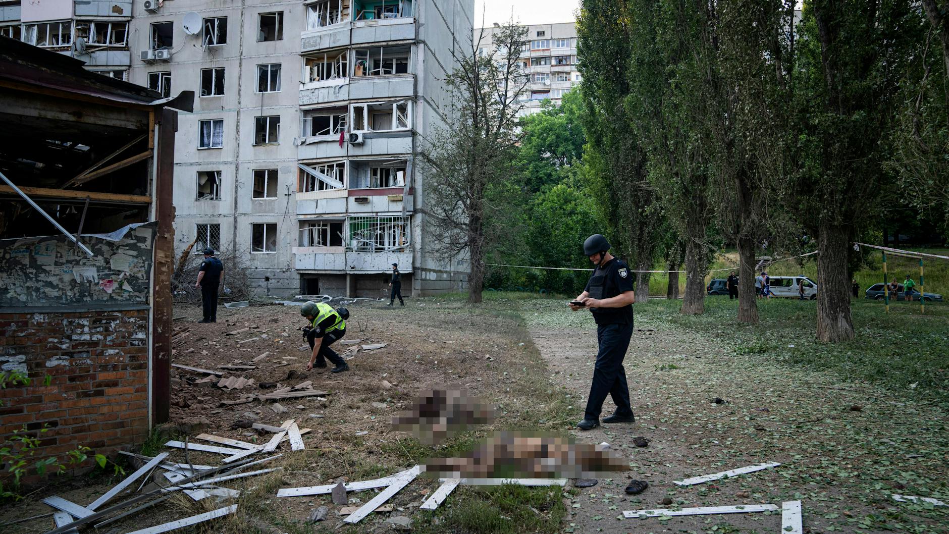 Polizisten fotografieren die Toten.