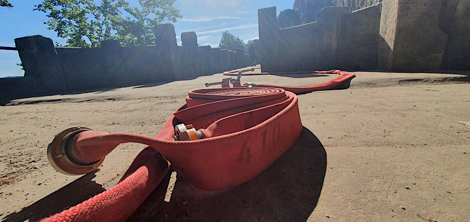 HANDOUT - Ein Löschschlauch der Feuerwehr auf der Bastei. Mehr als 100 Feuerwehrleute waren im Einsatz, um die Flammen und Glutnester unter Kontrolle zu bekommen.  terzgebirge/dpa