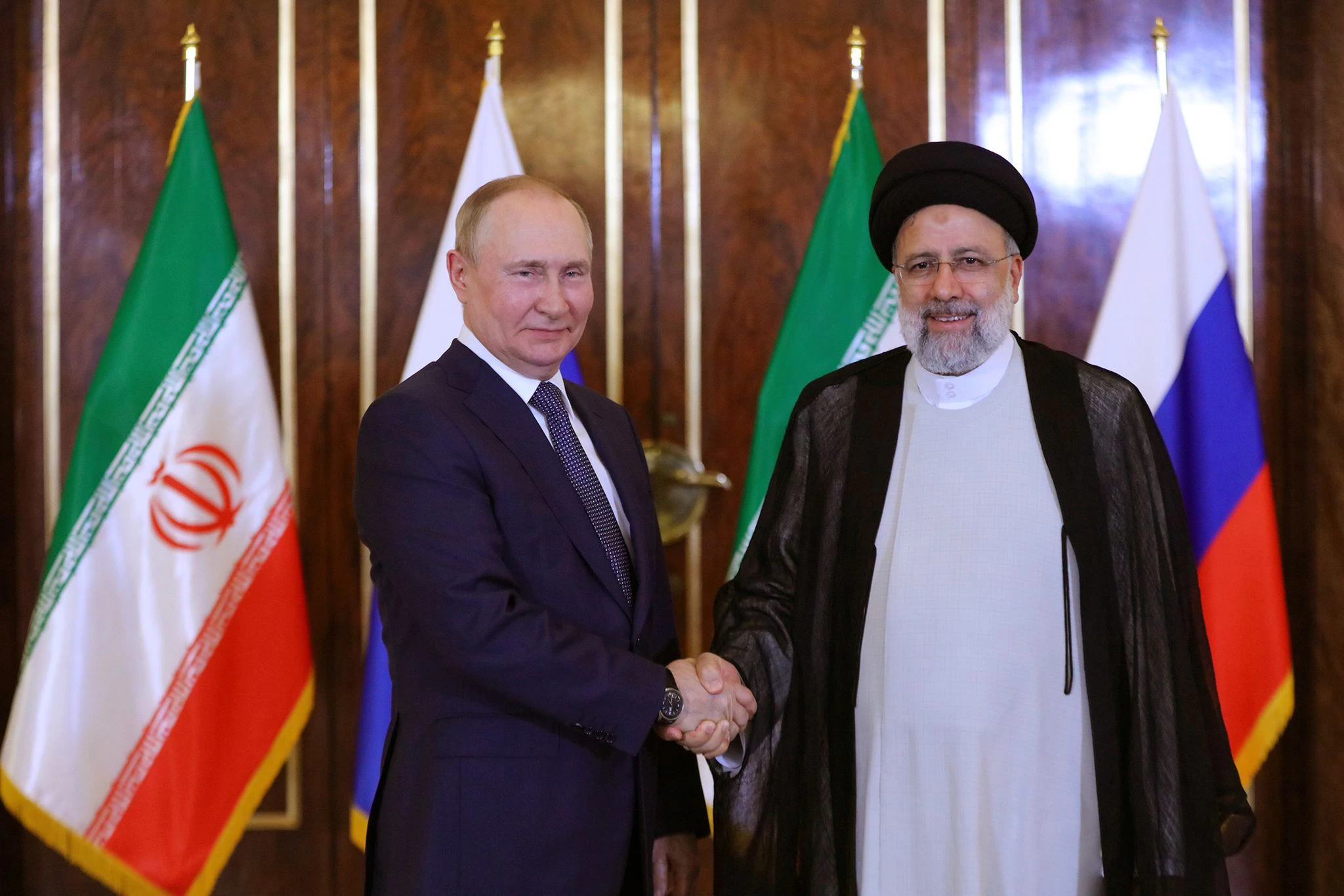 HANDOUT - Der iranische Präsident Ebrahim Raisi (r) empfängt Wladimir Putin in Teheran.  