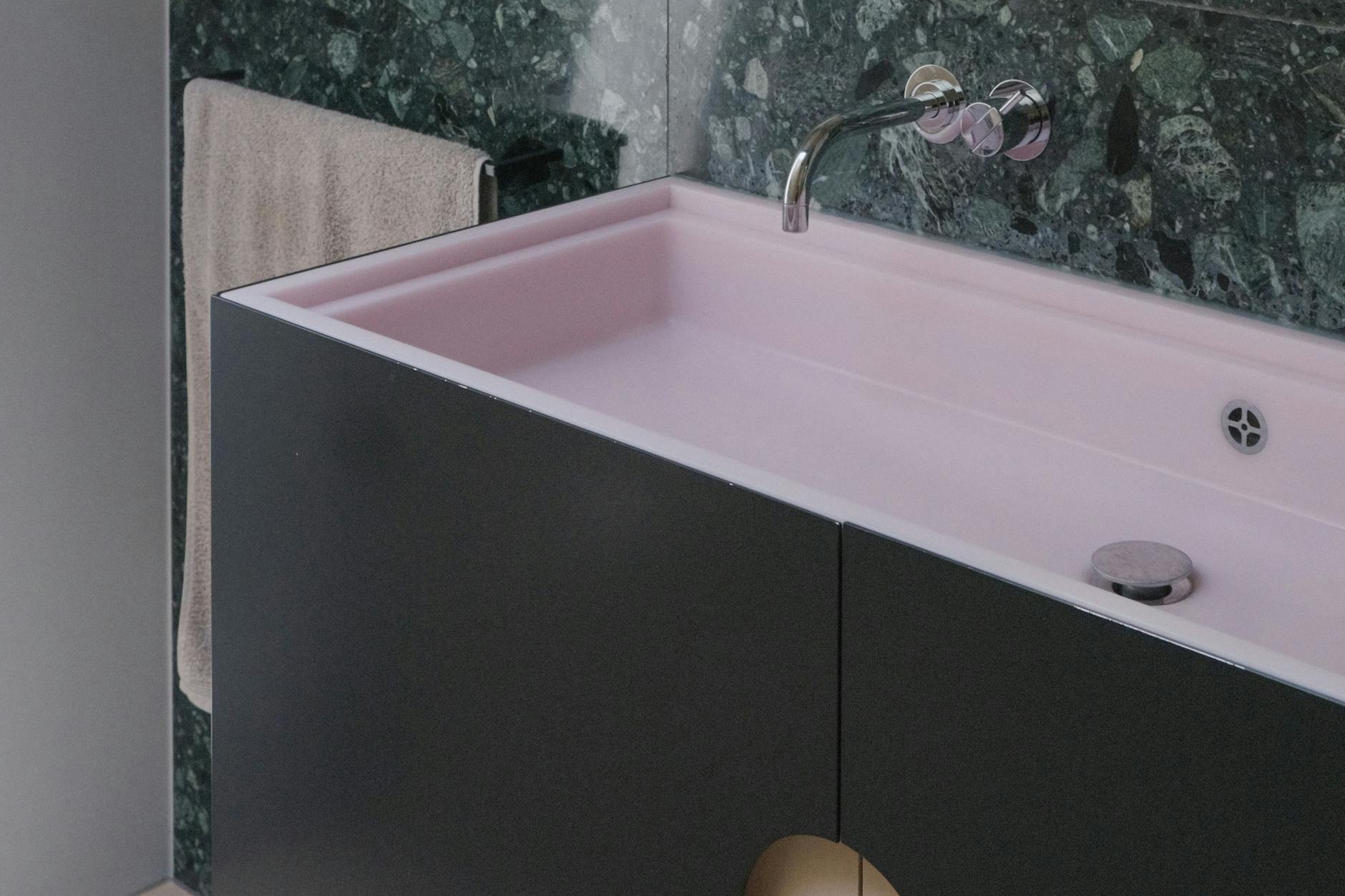 Schönes Farbspiel: Das Waschbecken besteht aus grünem Marmor, schwarzem Stahl und rosafarbenem Acrylstein.