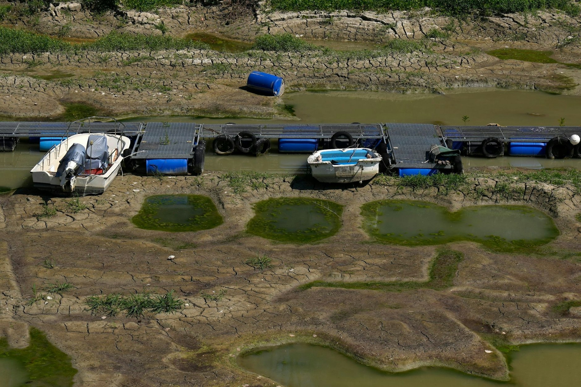 Boote liegen in einem Touristenhafen auf dem ausgetrockneten Flussbett des Pos. Die Dürre in Italien hat die für die Bewässerung wichtigen Flüsse austrocknen lassen.  