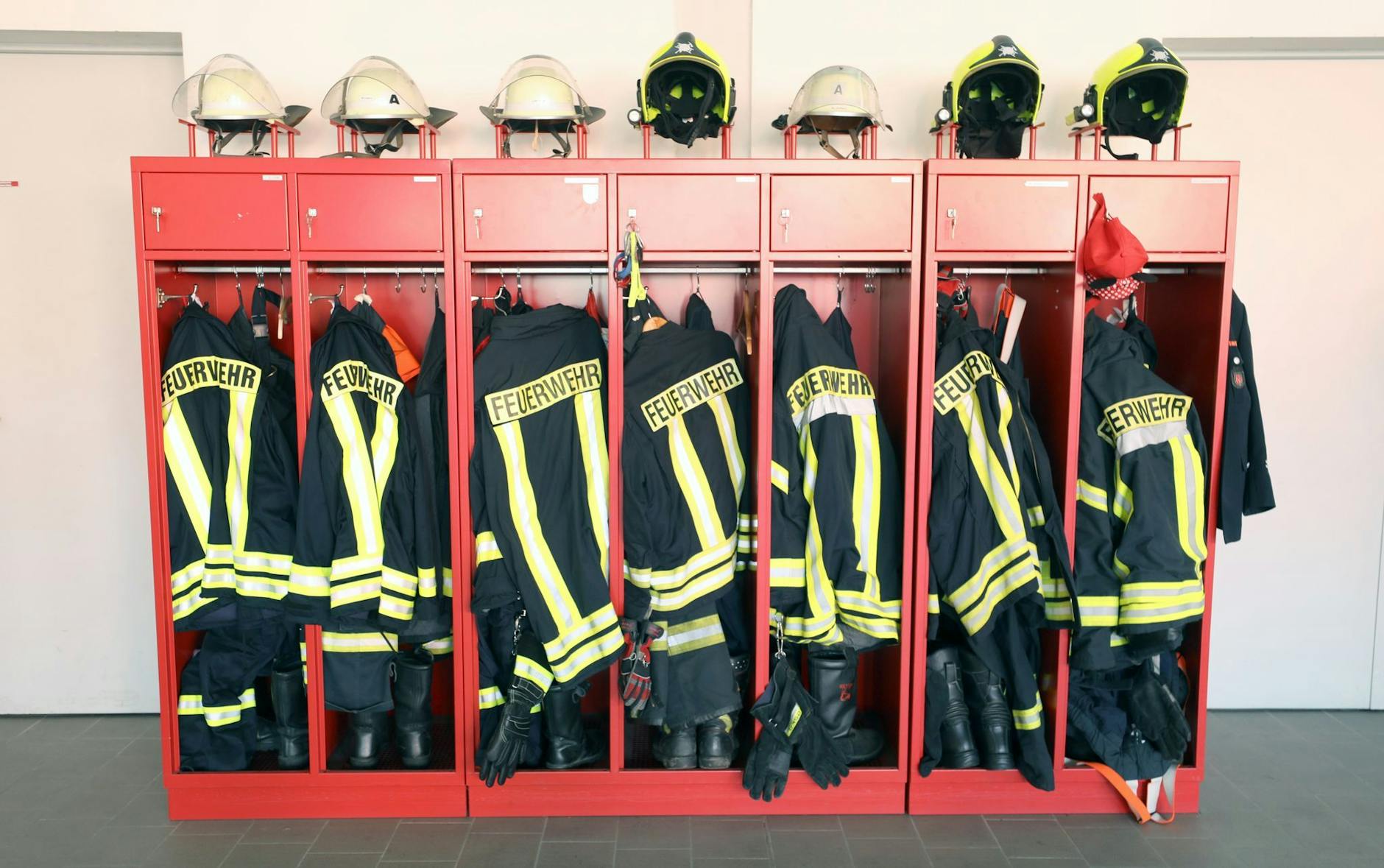 ARCHIV - Ein Schrank mit Jacken und Helmen einer Freiwilligen Feuerwehr. d