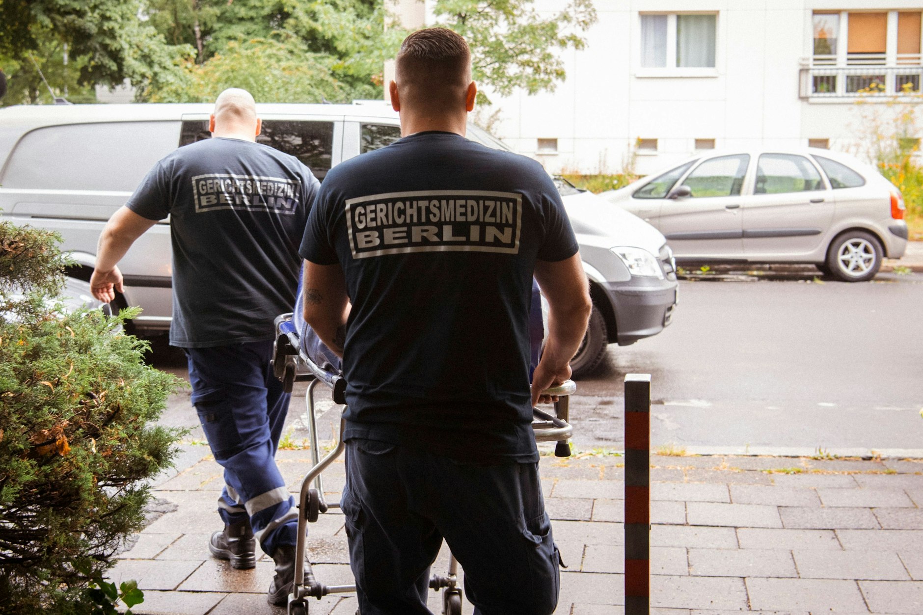 Mitarbeiter der Gerichtsmedizin transportieren eine Leiche aus einer Wohnung in einem Mehrfamilienhaus in der Singerstraße zu ihrem Fahrzeug.