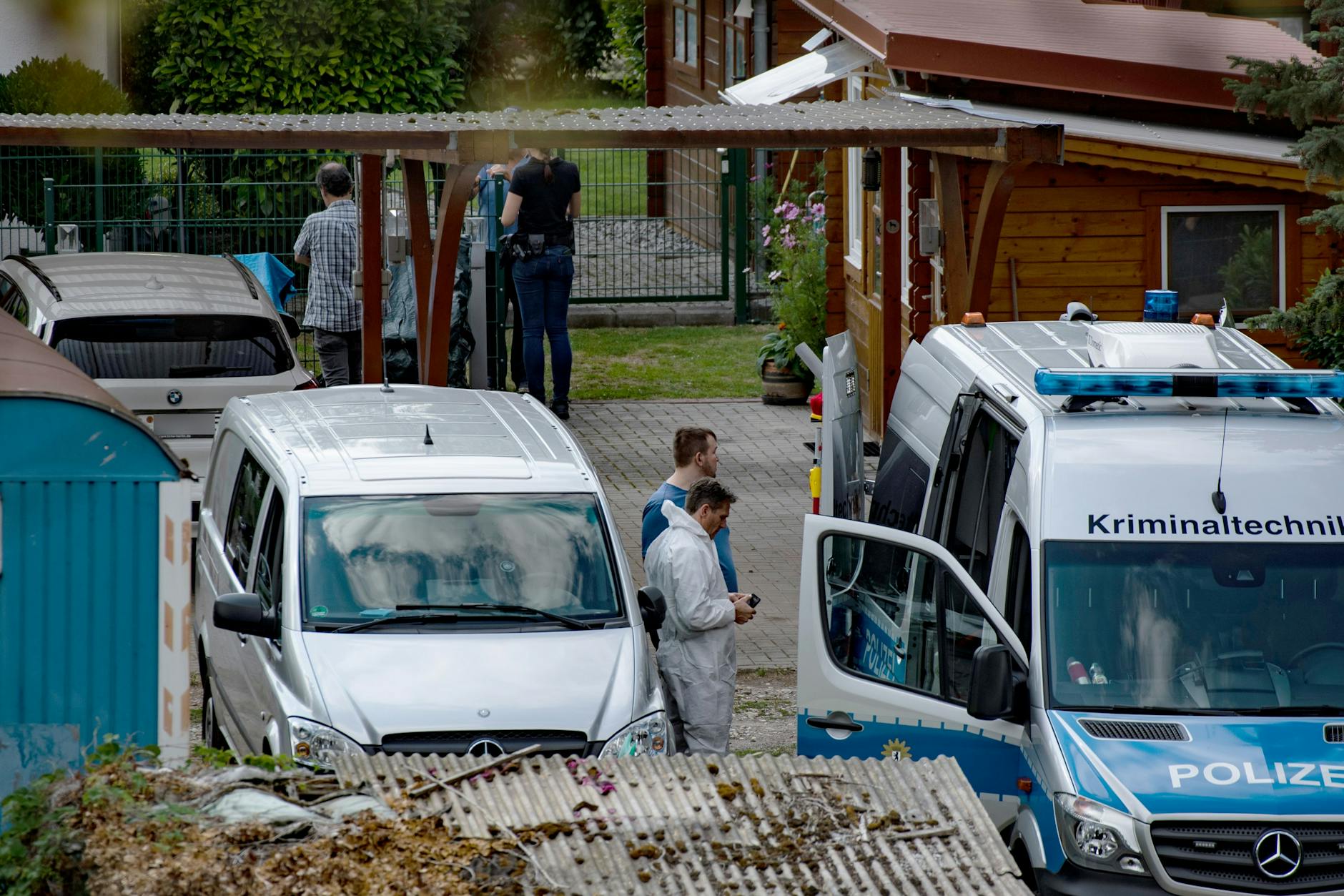 Kriminaltechniker und Ermittler stehen auf dem Grundstück nahe der Heerstraße. Neben einem Bootsverleih wurde ein Mann erschossen. Der mutmaßliche Schütze starb bei einem Brand.