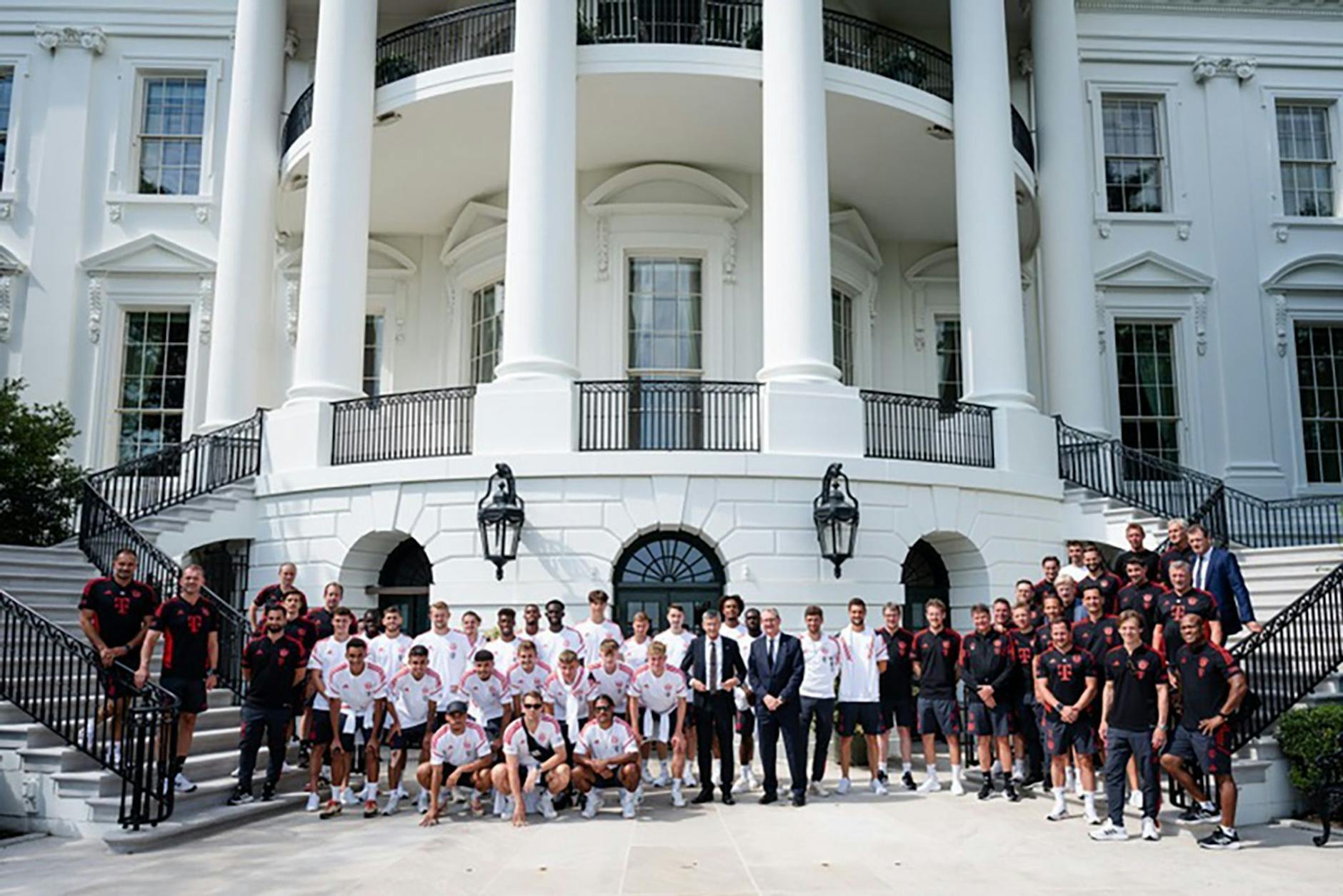 HANDOUT - Verantwortliche, Spieler, Trainer und Betreuer vom FC Bayern München posieren vor dem Weißen Haus für ein Gruppenbild..