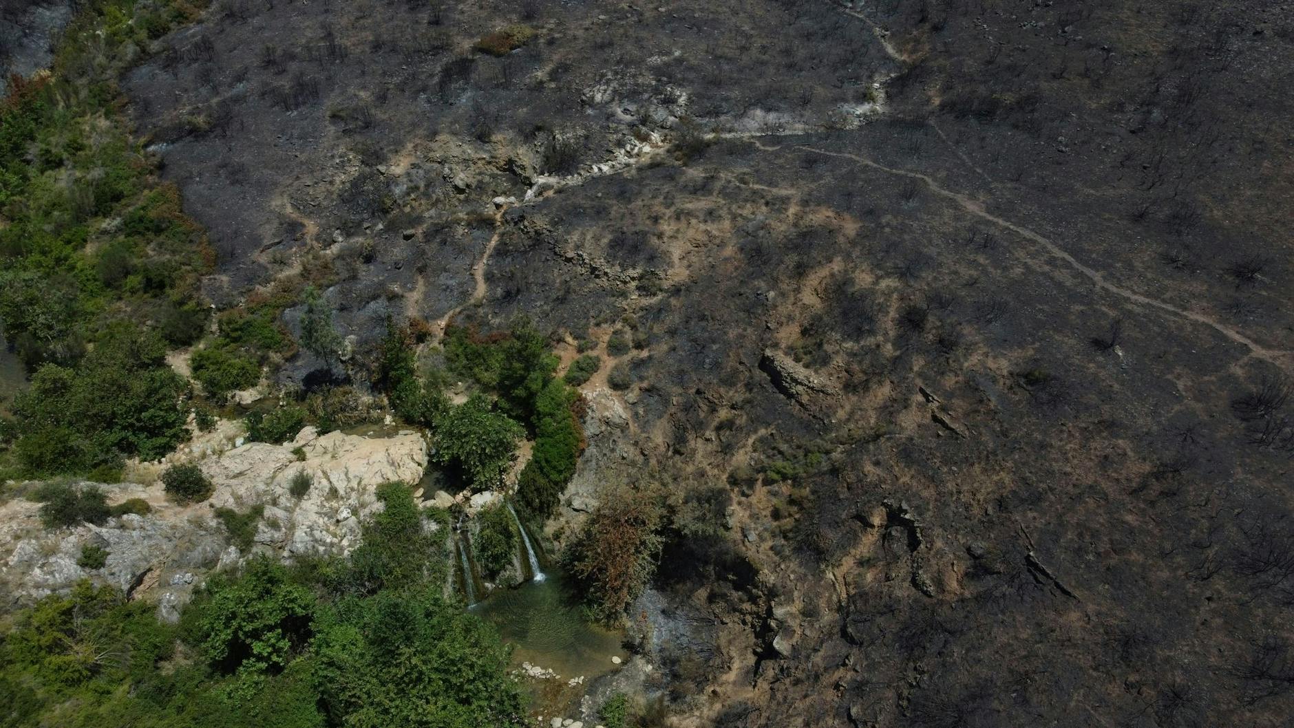 Blick auf den Valanaris-Wasserfall neben einem verbrannten Gebiet in Drafi auf dem Penteli-Berg.