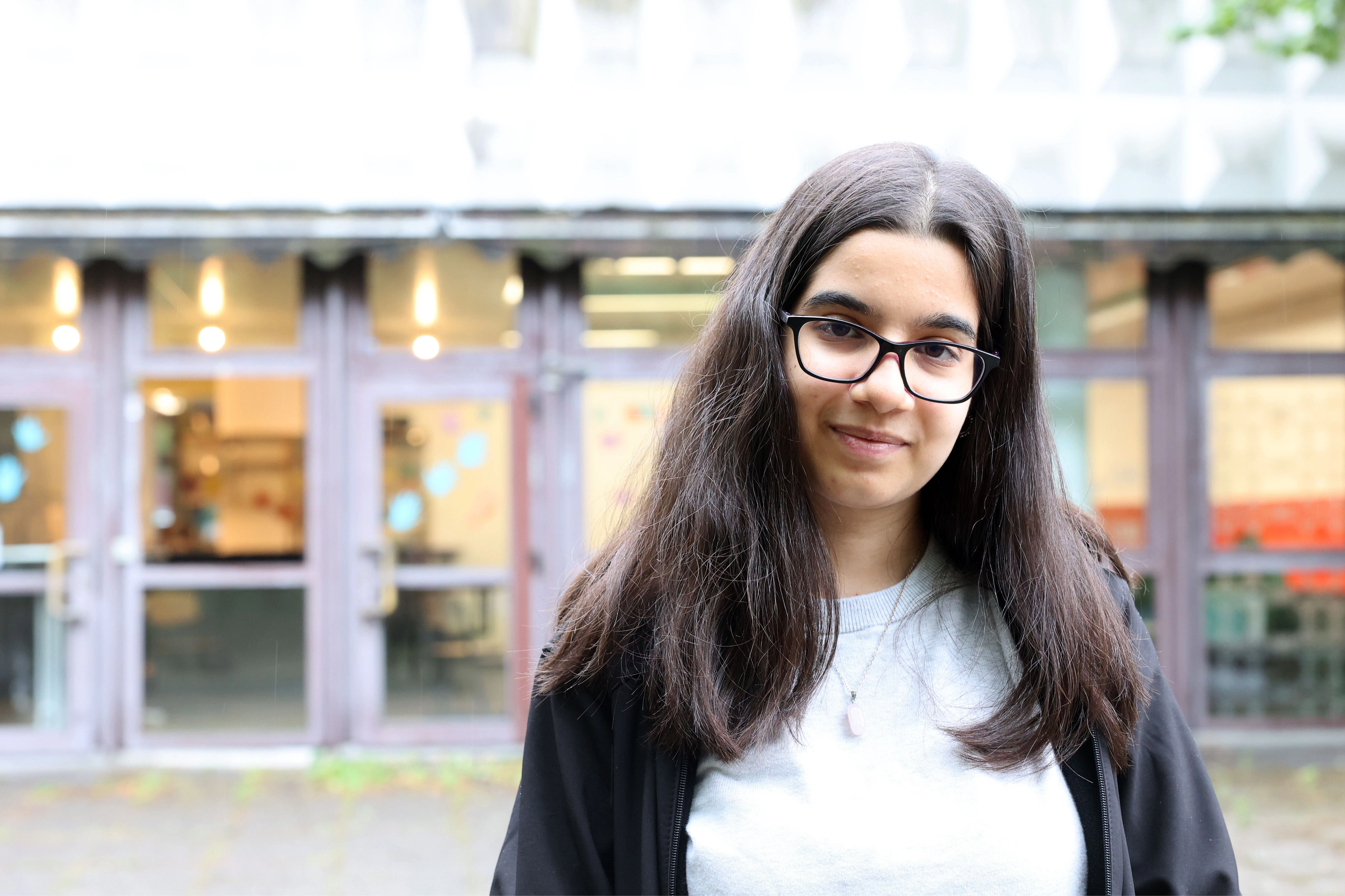 Arjin (16) hat mit ihrer Erzählung „Ausgeschieden“ beim Europäischen Wettbewerb einen Bundespreis gewonnen. Hier steht sie vor dem Eingang der Ernst-Reuter-Schule.