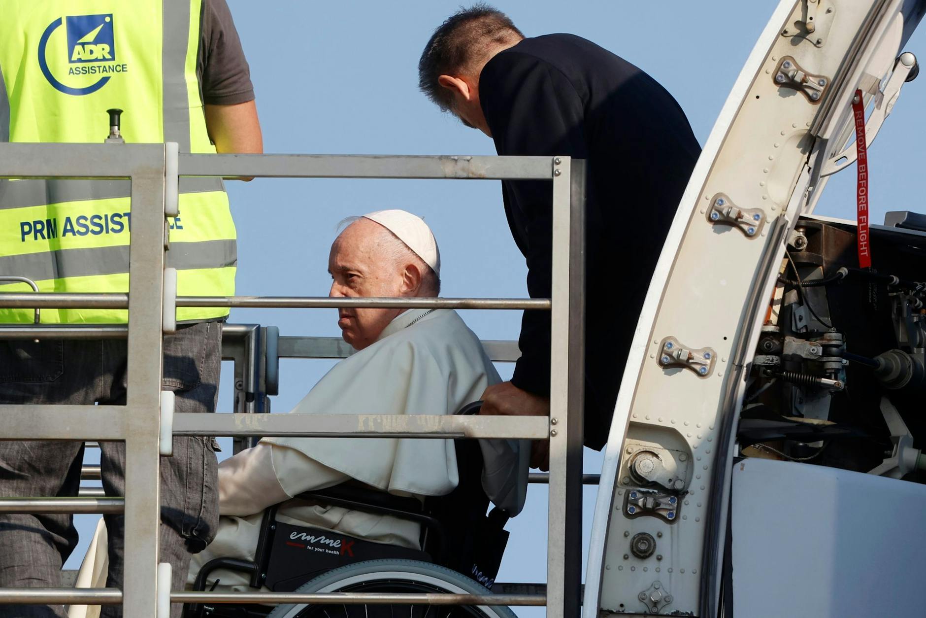 Papst Franziskus (l.) wird in einem Rollstuhl in ein Flugzeug am Internationalen Flughafen Leonardo da Vinci geschoben.