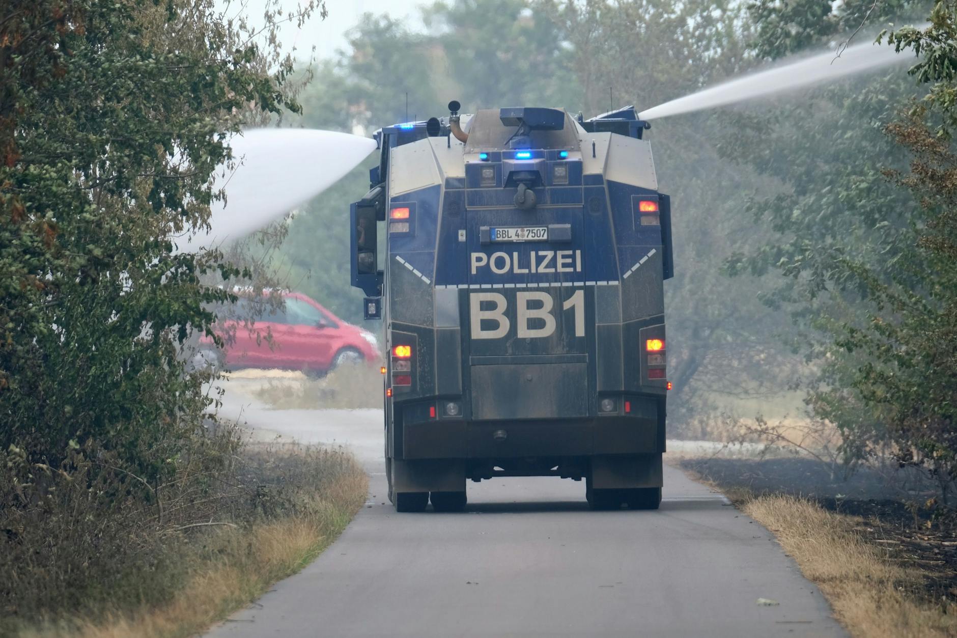 Ein Wasserwerfer der Polizei löscht Glutnester eines Waldbrandes im Landkreis Elbe-Elster. Ein Experte rät nun zum Einsatz von Löschpanzern.