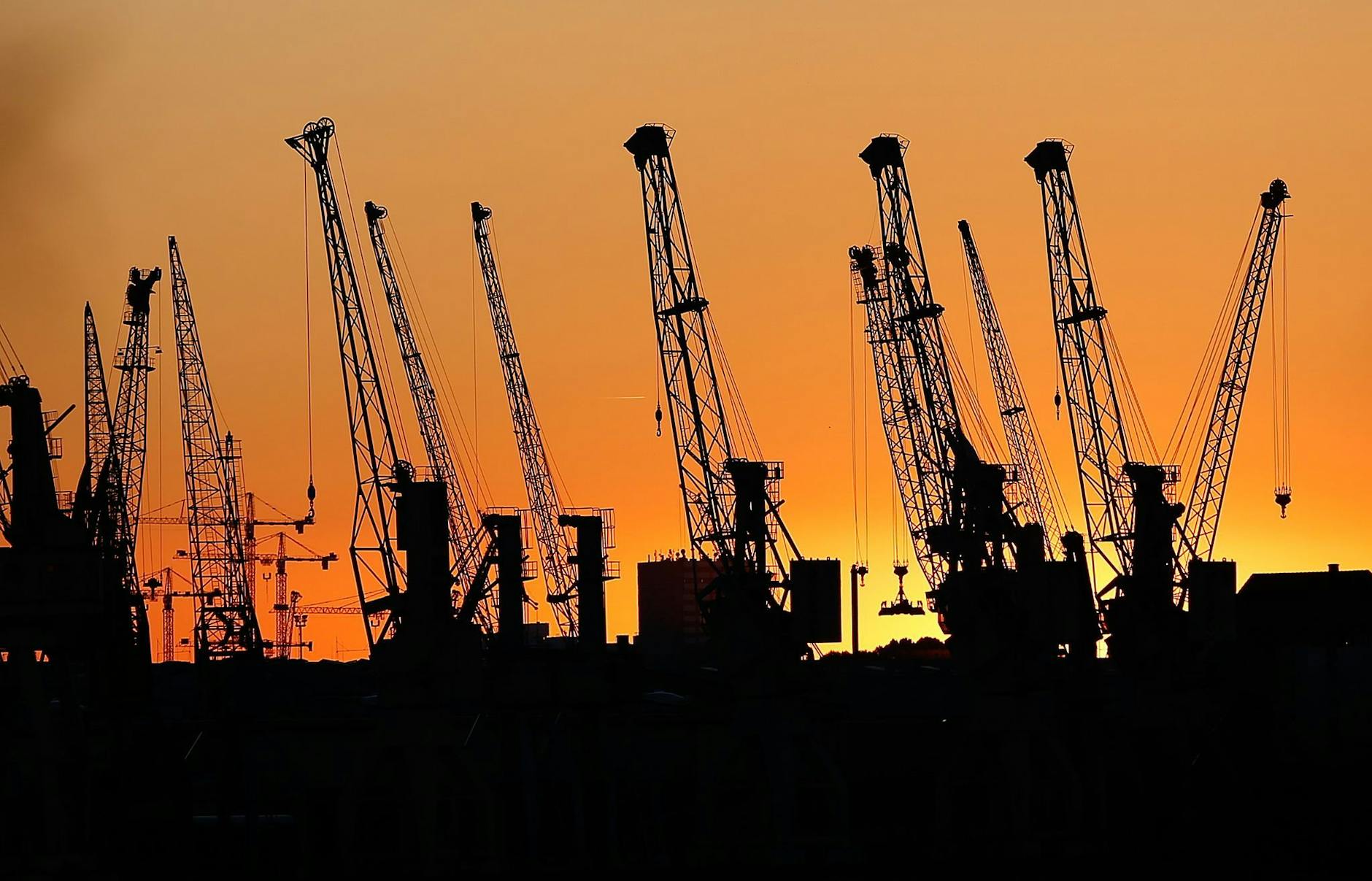 ARCHIV - Kräne im Hamburger Hafen: Der IWF schraubt seine Wachstumsprognose für die Wirtschaft nach unten.