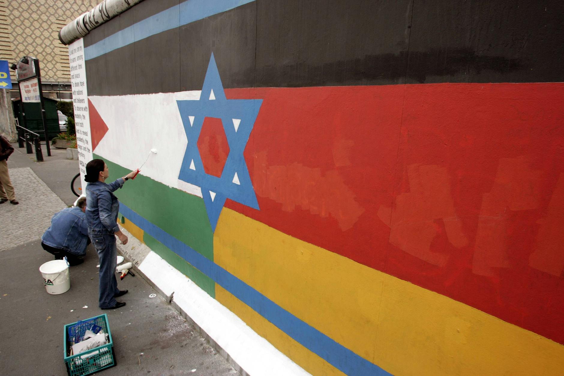 Maler und Fotograf Günther Schäfer und Malerin Varda Carmeli vereinigen unter dem Titel „Vaterland“ die Flaggen Israels, Palästinas und Deutschlands auf einem Mauerrest an der East Side Gallery in Berlin.