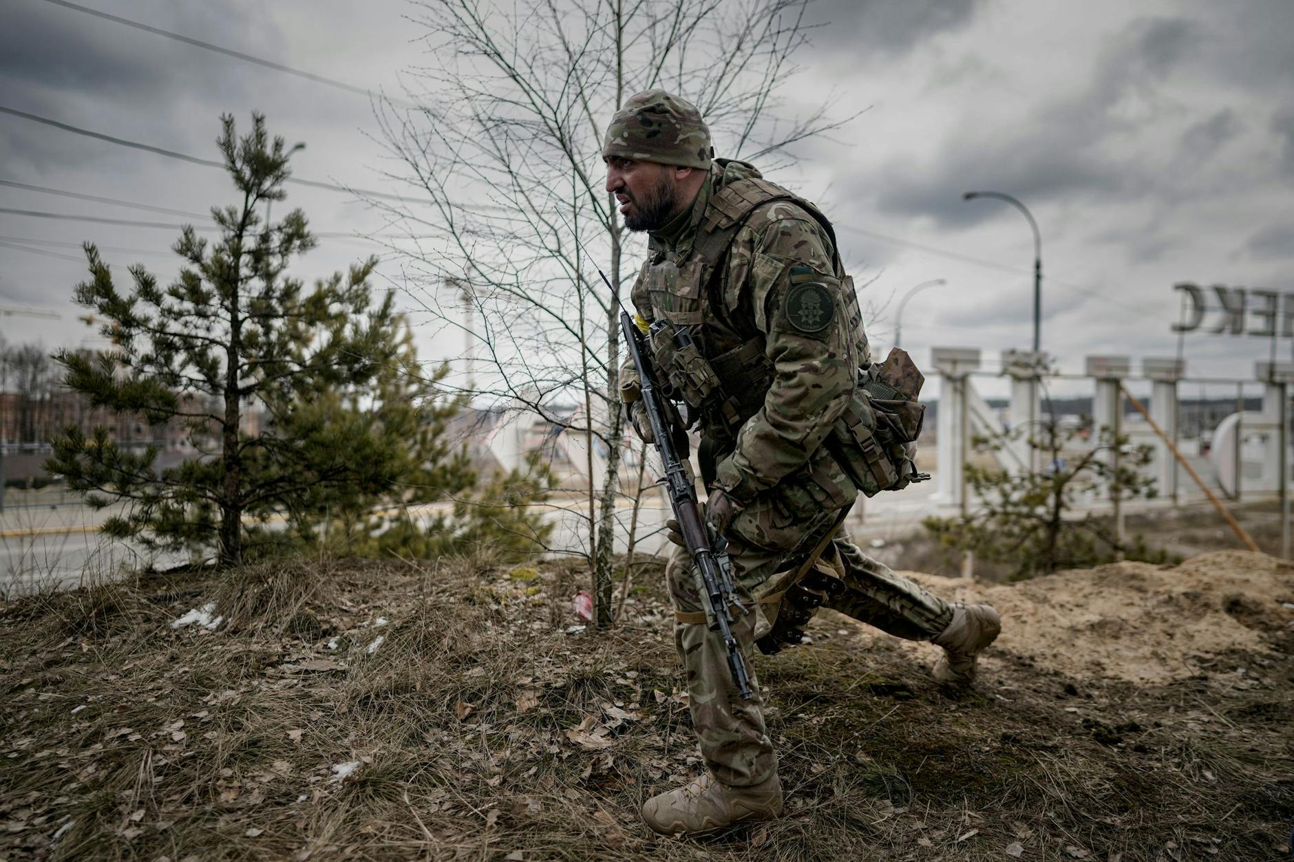 ARCHIV - Ein ukrainischer Soldat geht am Stadtrand von Kiew in Schussposition.