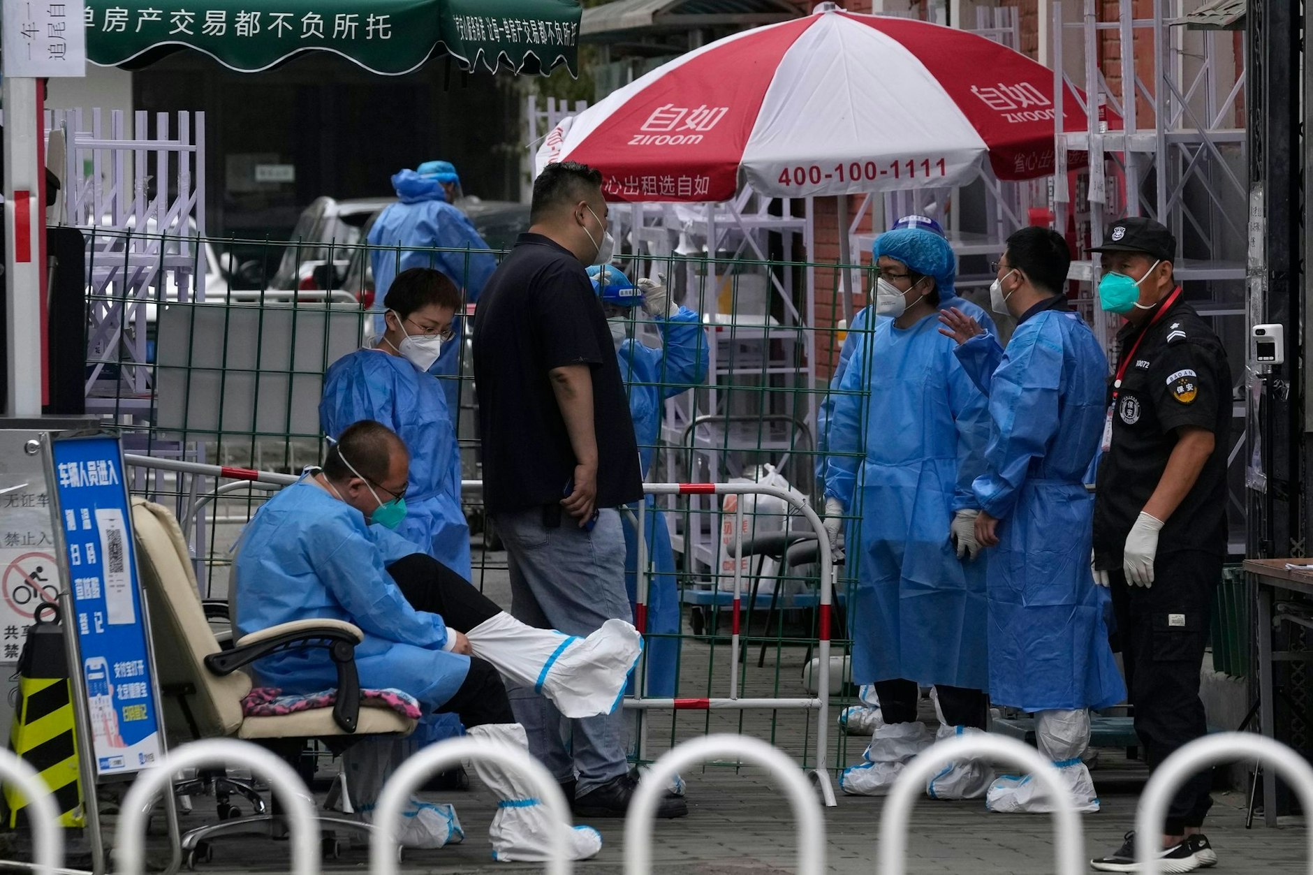 ARCHIV - Medzinisches Personal steht am Eingang einer abgeriegelten Gemeinde in Peking: Auf der Suche nach dem Ursprung des Coronavirus Sars-CoV-2 kommt Wissenschaftlern zufolge wahrscheinlich ein Markt in Wuhan in Betracht.  