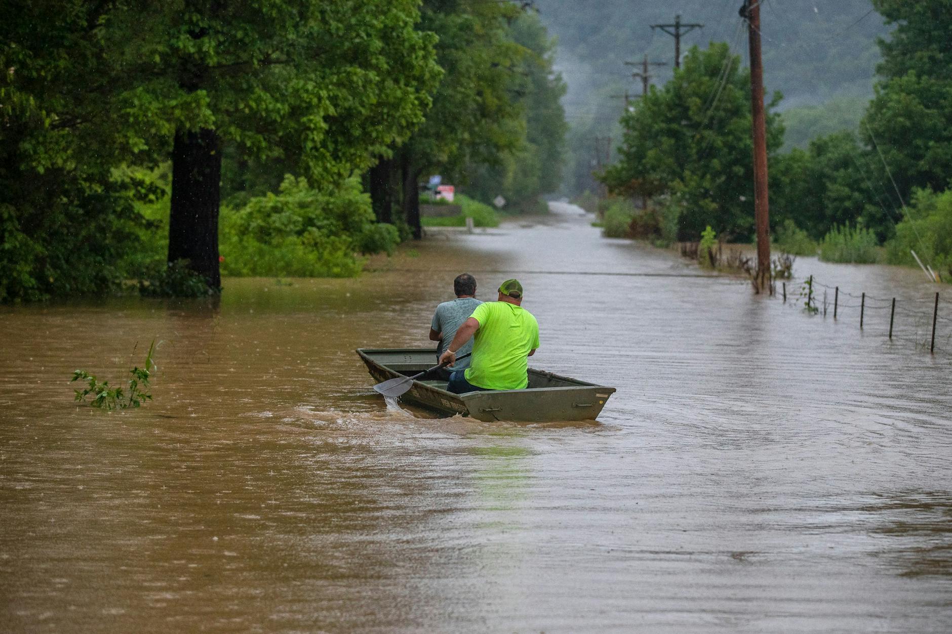 Männer fahren in einem Boot auf einer überfluteten Straßen in Breathitt County.