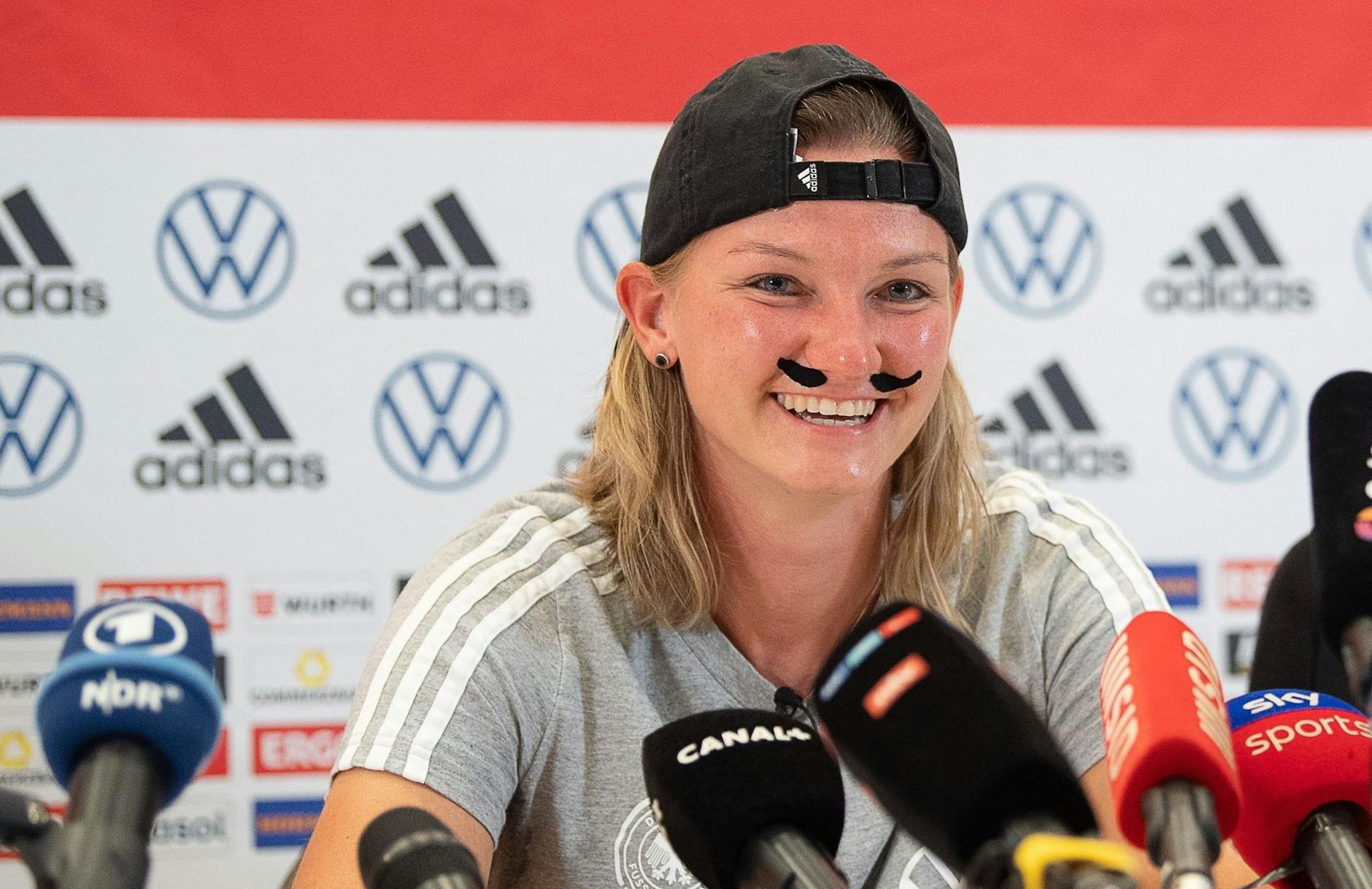 dpatopbilder - Alexandra Popp zeigte sich auf der Pressekonferenz mit einem Schnauzer.