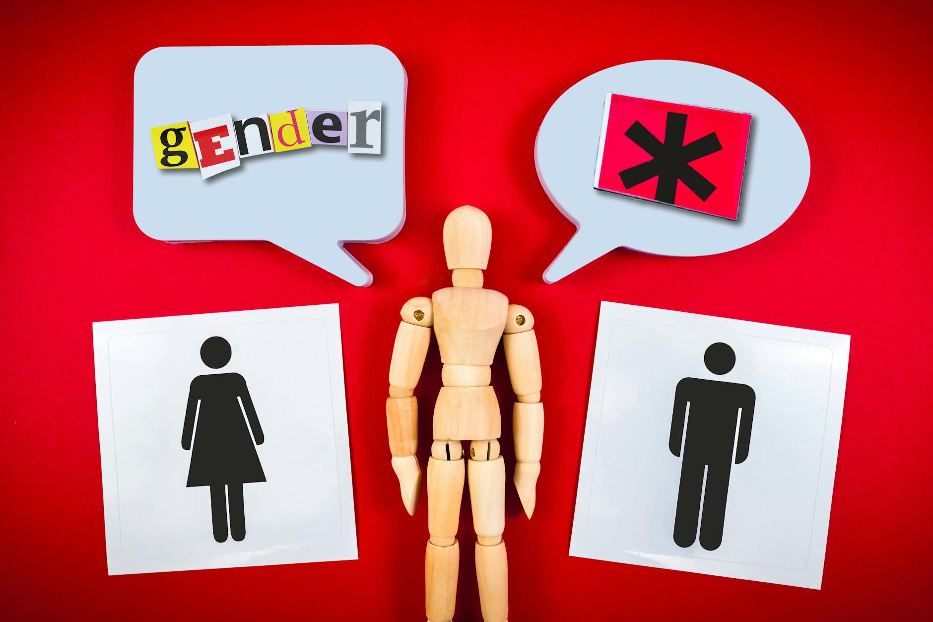 Gliederpuppe zwischen Piktogrammen von Mann und Frau