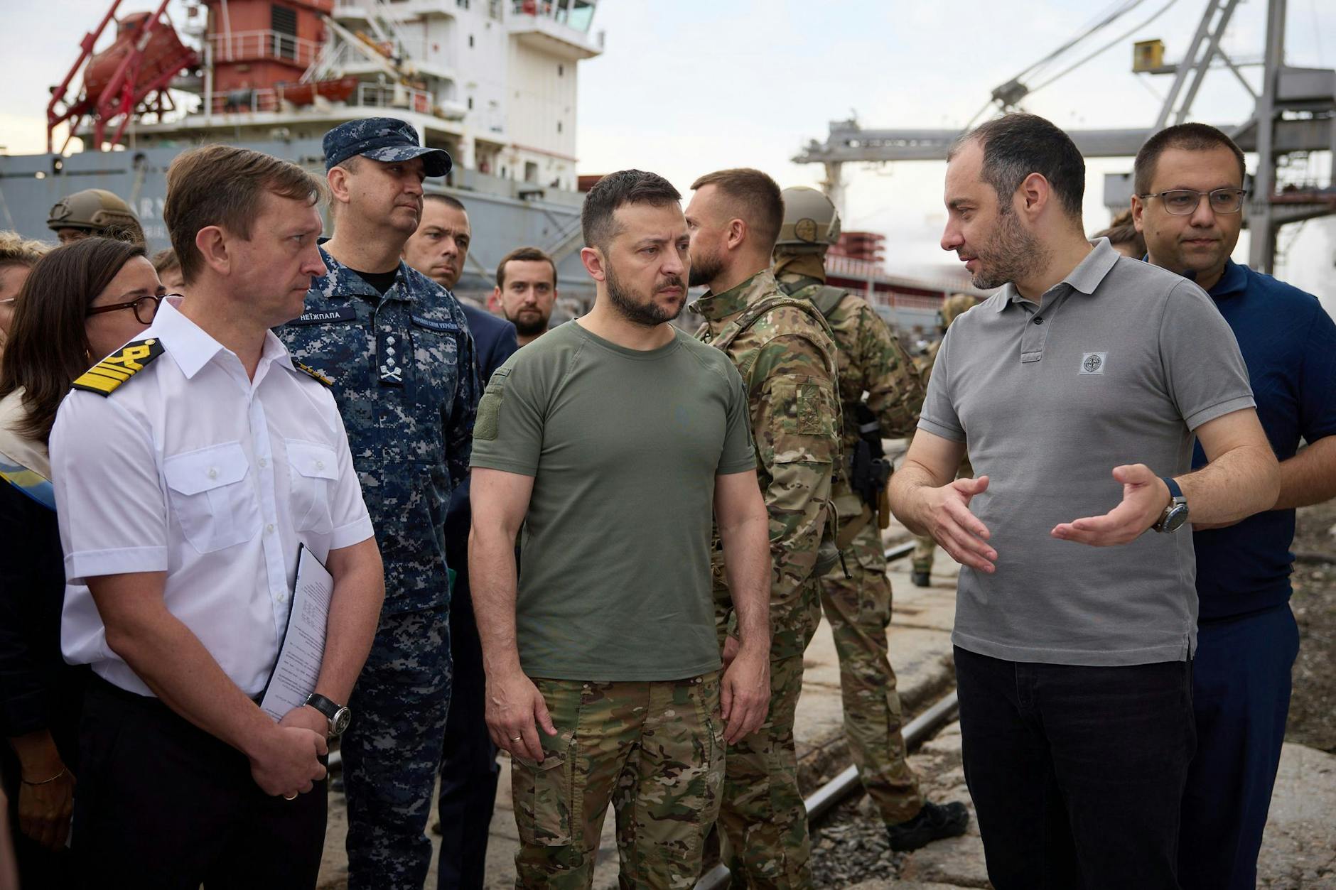 Ukraines Präsident Wolodymyr Selenskyj (Bildmitte) besucht einen Hafen während der Verladung von Getreide auf ein türkisches Schiff.