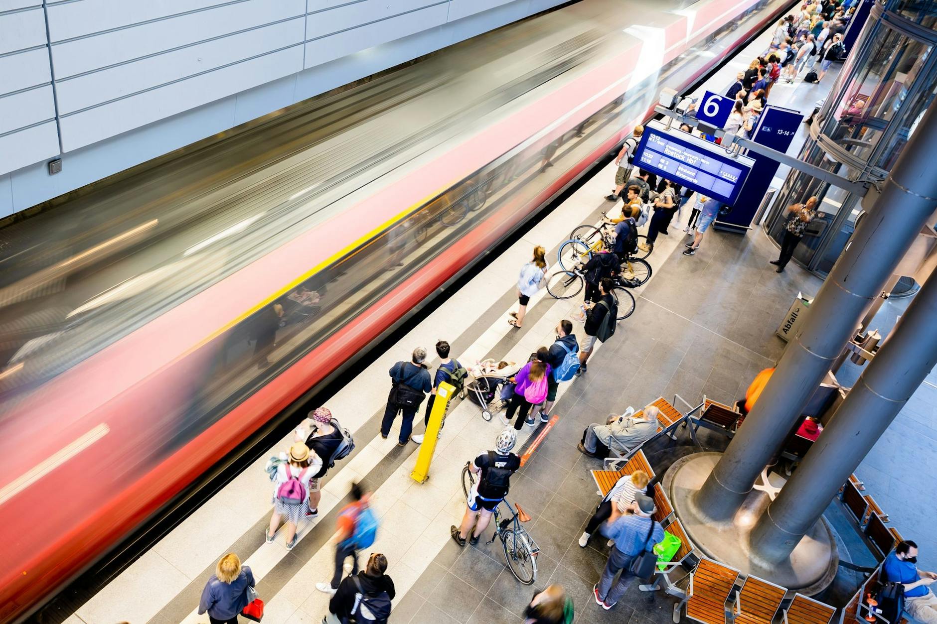 Fahrgäste im Untergeschoss des Berliner Hauptbahnhofs. Ein Regionalzug fährt ein.