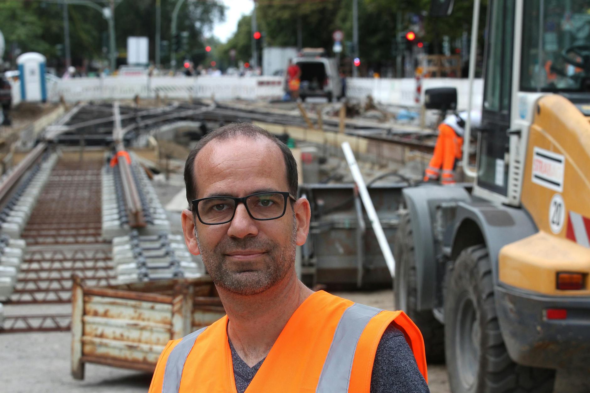Holger Pöhland, Mitglied des BVG-Projektteams, auf der Straßenbahnbaustelle in der Turmstraße in Moabit. Hinter ihm wird an der Superweiche gearbeitet.