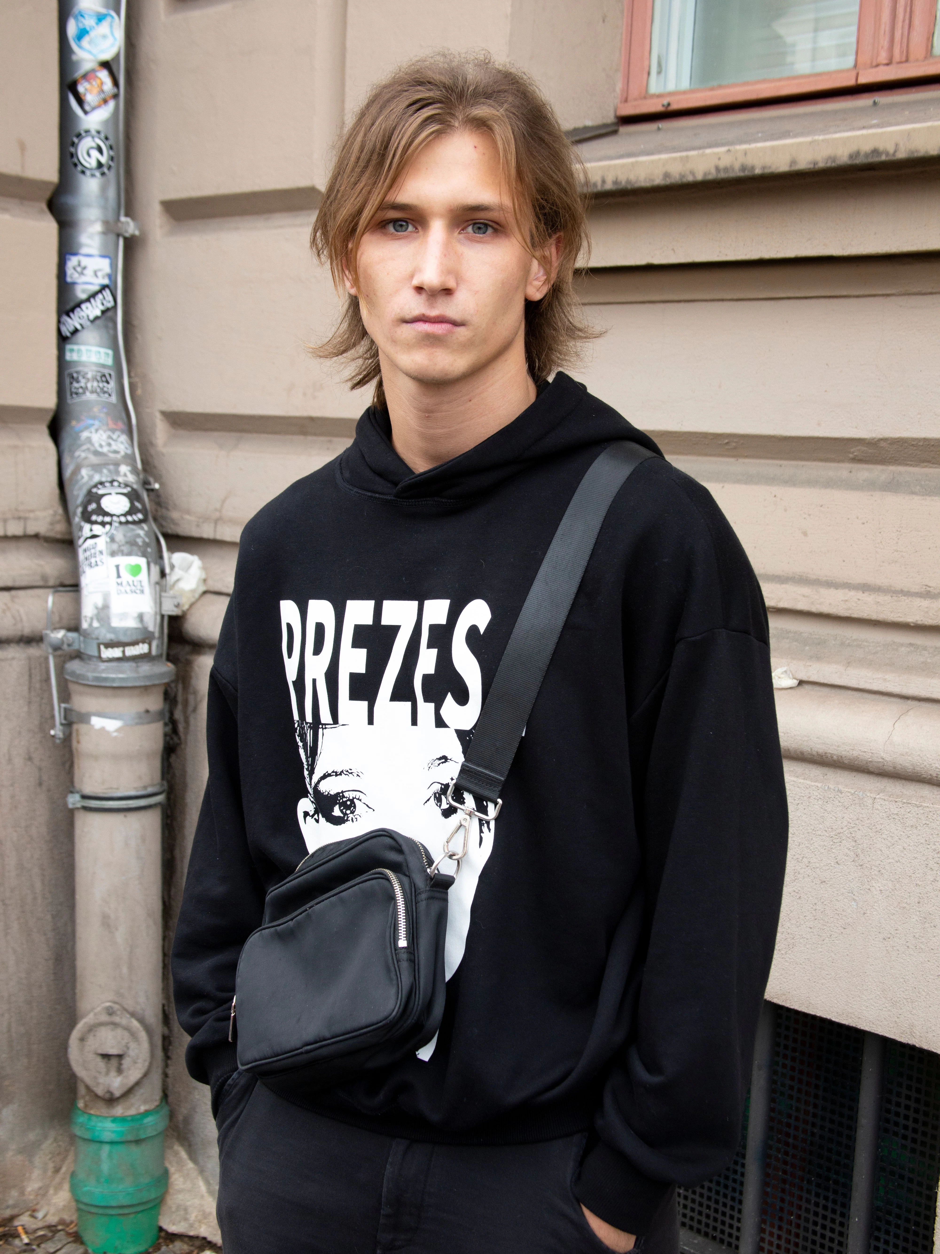 Bevor der Krieg ausbrach, lebte Robin in Kiew. Er arbeitet als Krypto-Seller, was ja praktisch von überall aus funktioniert, wo es Internet gibt. Also auch in Breslau. Den Hoody hat er von seinem Freund, dem Rapper Jacuś, der im Herbst immerhin mit Tommy Cash auf Tour geht. Außerdem trägt Robin eine Vintage-Hose und Nike Shox.