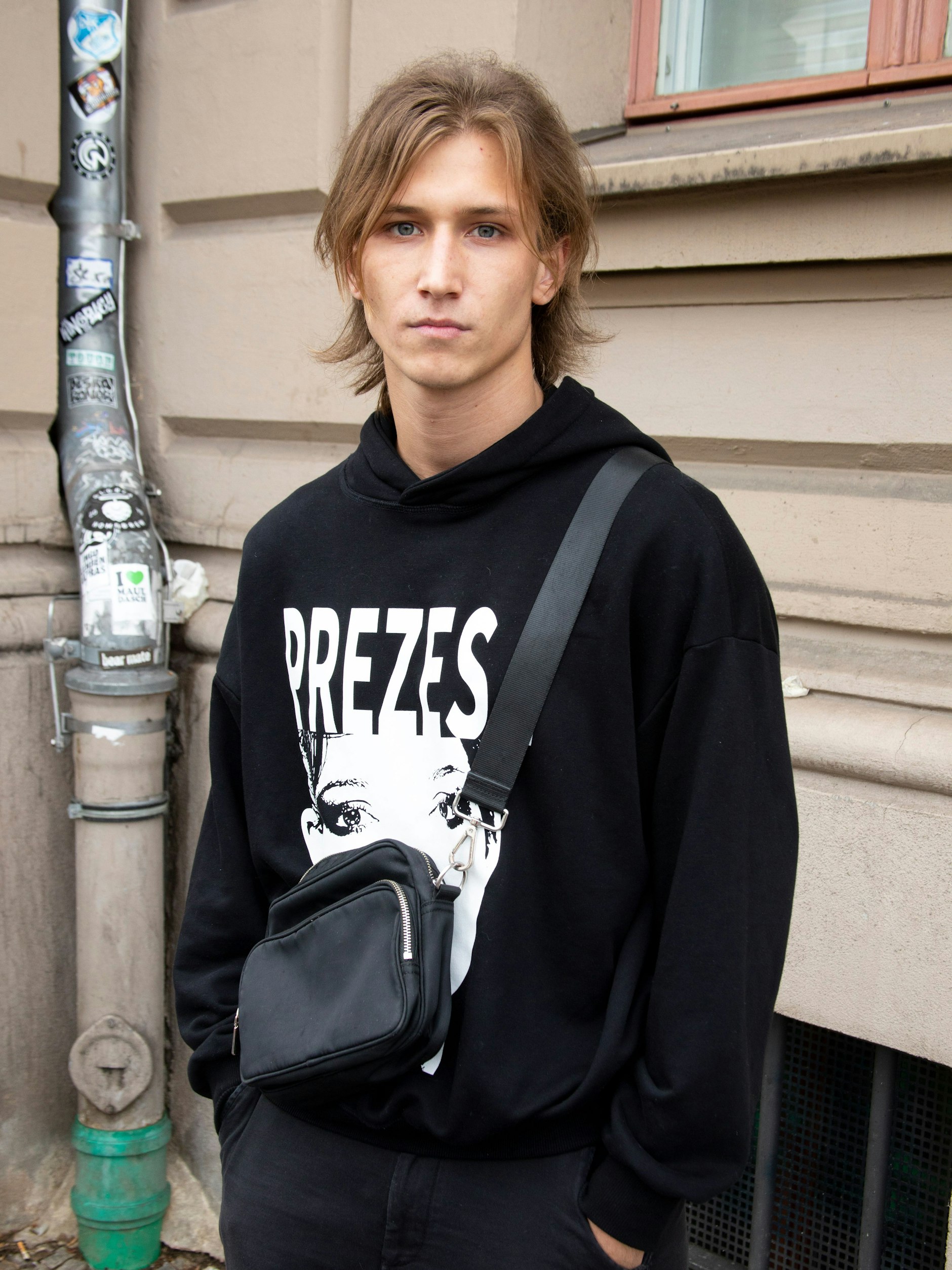 Bevor der Krieg ausbrach, lebte Robin in Kiew. Er arbeitet als Krypto-Seller, was ja praktisch von überall aus funktioniert, wo es Internet gibt. Also auch in Breslau. Den Hoody hat er von seinem Freund, dem Rapper Jacuś, der im Herbst immerhin mit Tommy Cash auf Tour geht. Außerdem trägt Robin eine Vintage-Hose und Nike Shox.