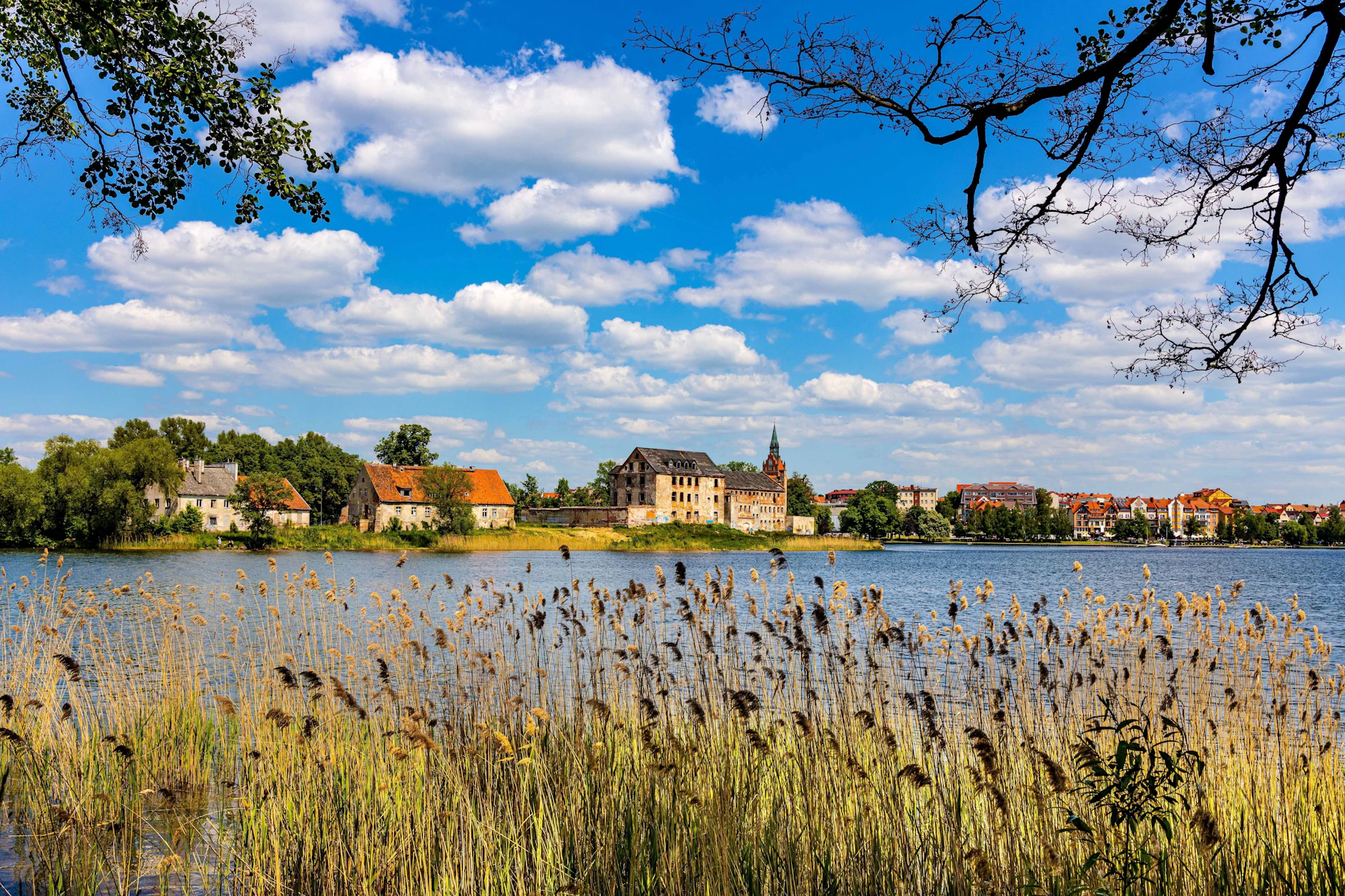 Panorama des historischen Stadtzentrums von Elk mit dem Turm der Herz-Jesu-Kirche und dem Schloss von Elk am Ufer des Sees Jezioro Elckie in Masuren.