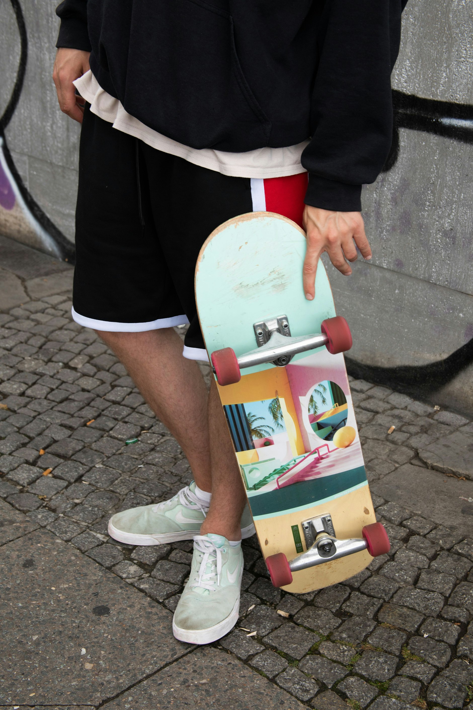 Passend zum pastellfarbenen Skateboard-Deck mit Motiv von Peter Tarka trägt Fabi Nike Dunks in Mint.